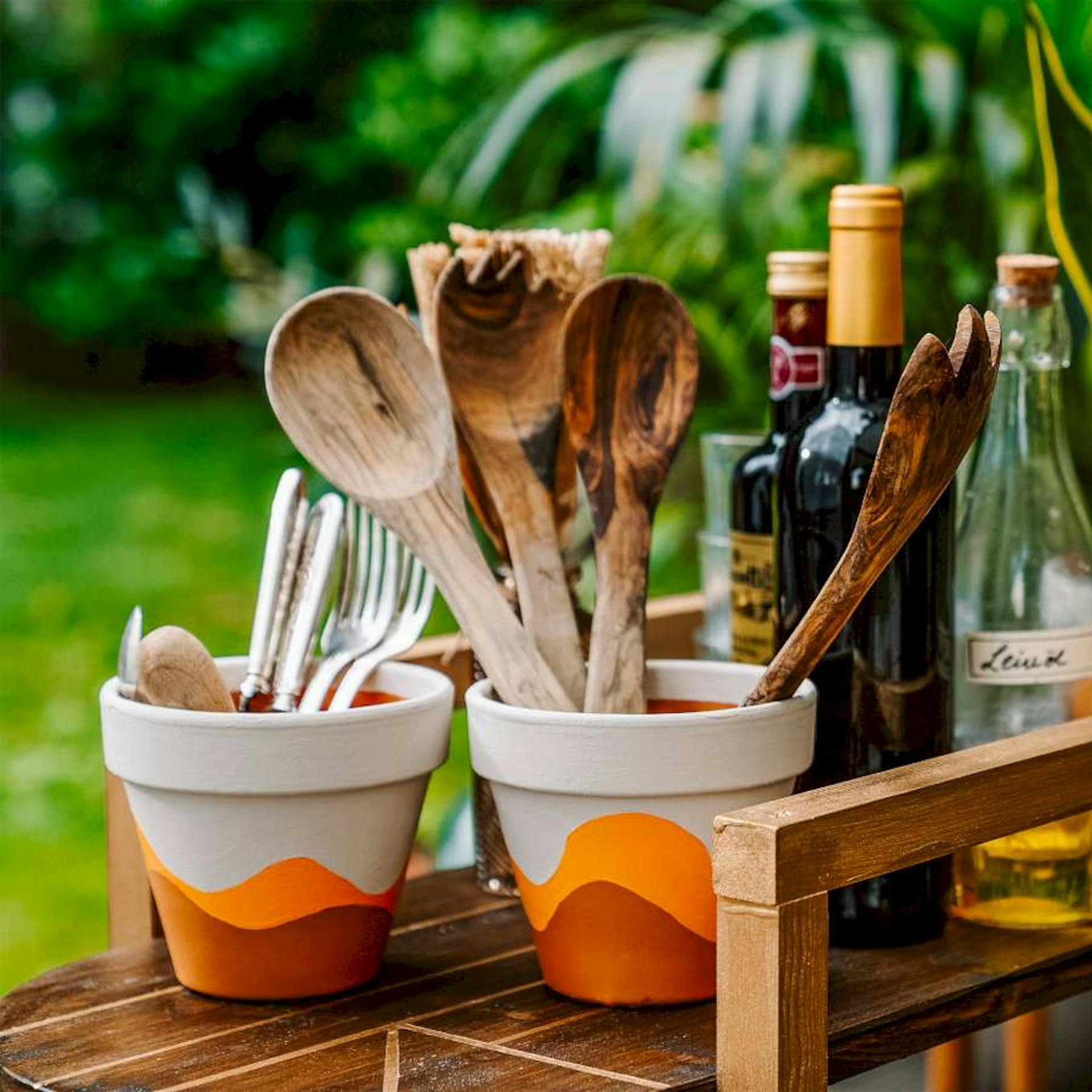 Selbstgemachte Terrakottatöpfe befüllt mit Besteck und Dekorationen.