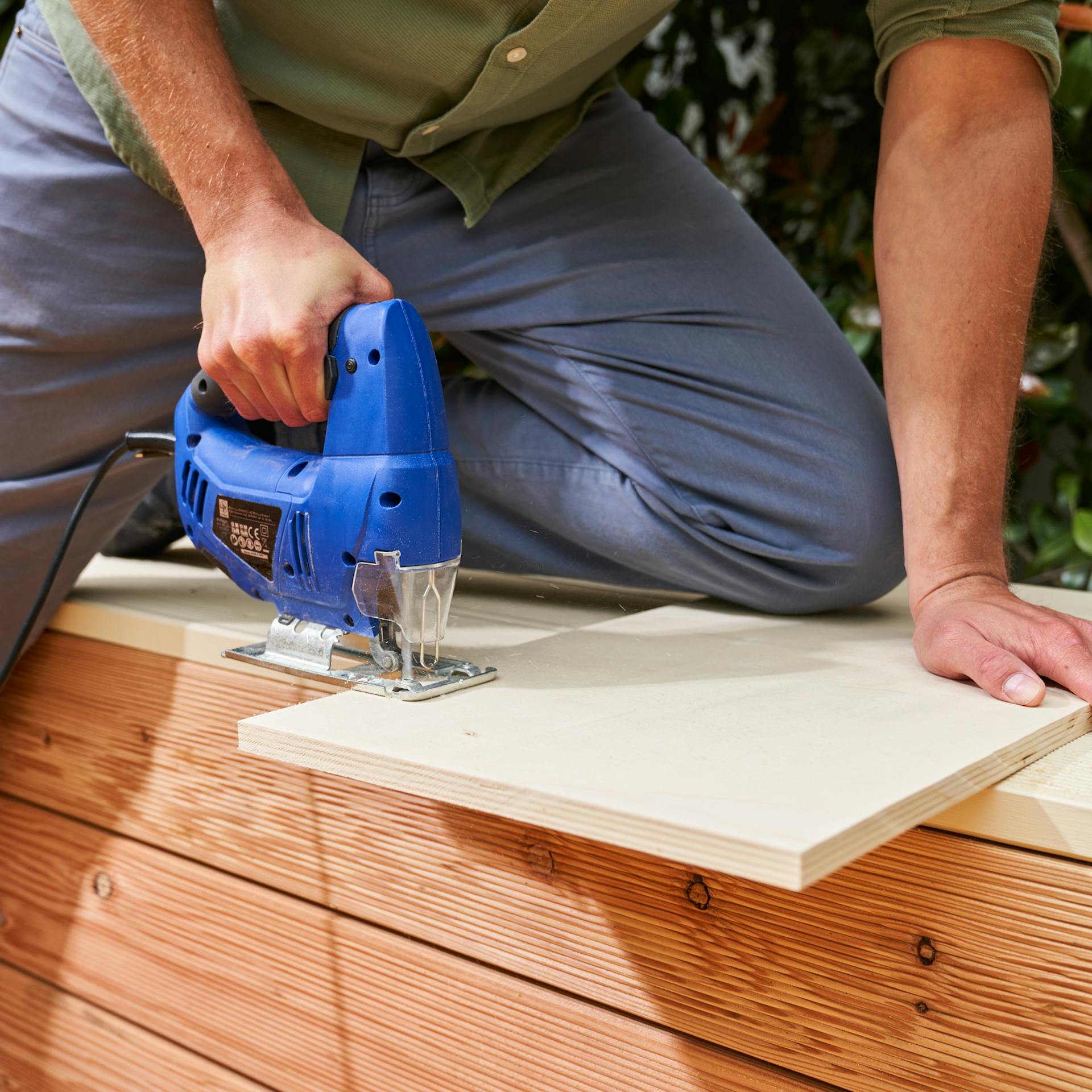 Heimwerker schneidet Bauteil für Becken eines Fußbads mit Stichsäge zu