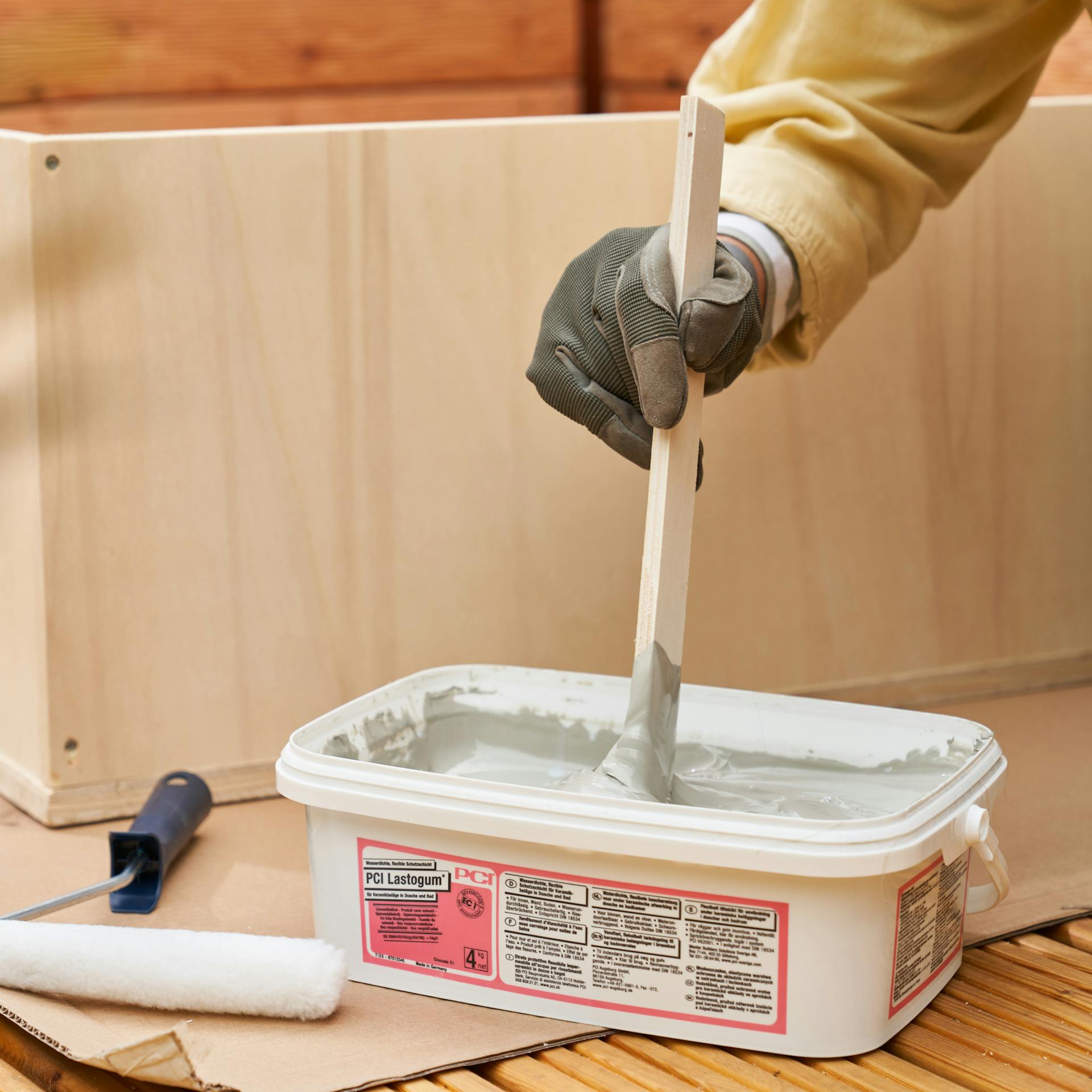 Heimwerkerin rührt Dichtungsmasse durch.