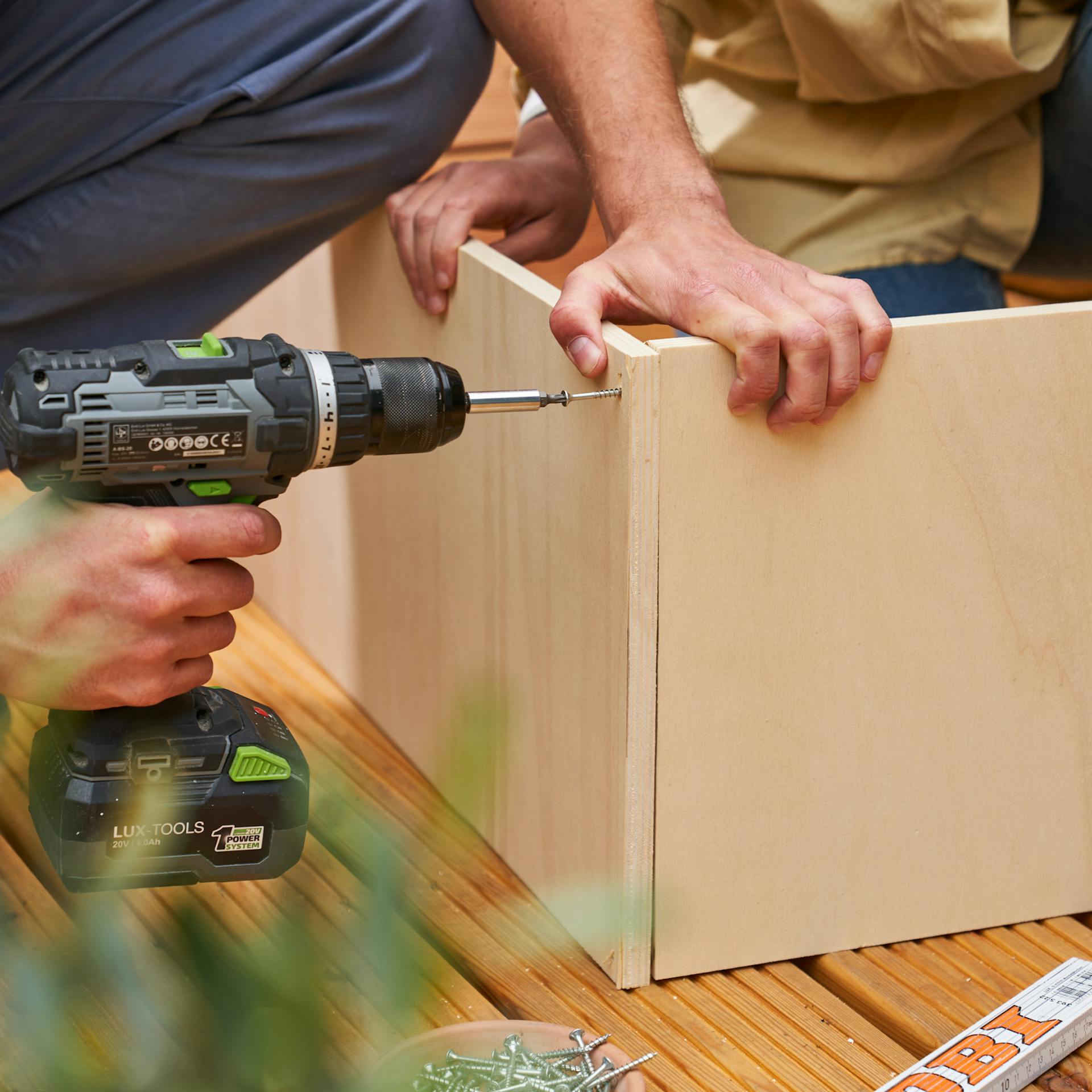 Zwei Heimwerker verschrauben das Becken des Fußbeckens.