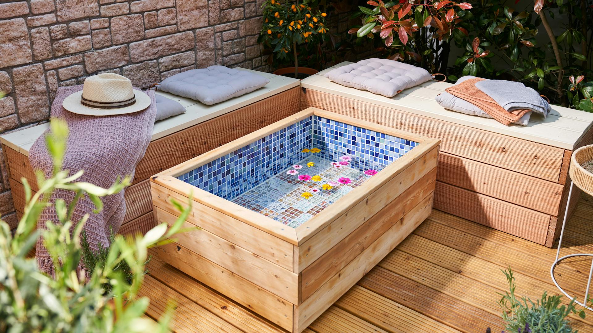 Selbstgebautes Fußbad steht in Entspannungsecke mit zwei Bänken auf Terrasse
