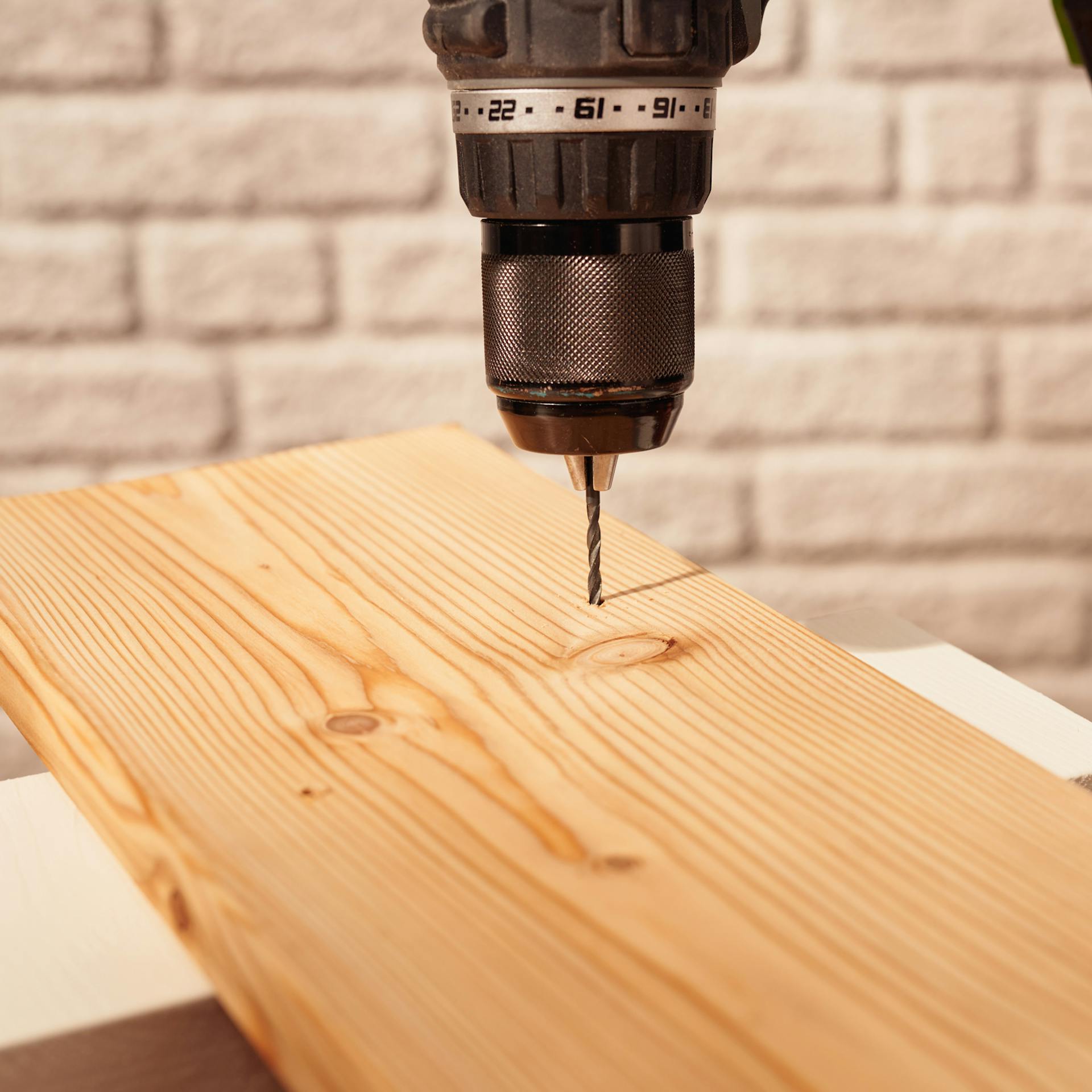 Egy fúró lyukat fúr egy deszkába.