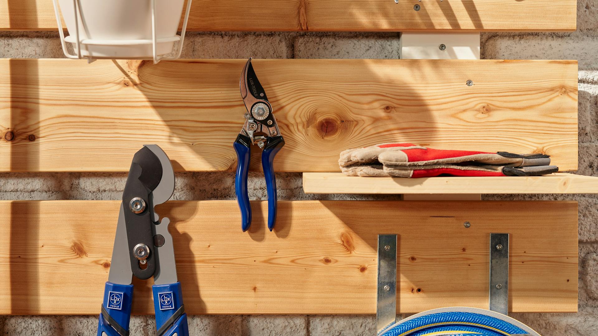 Metszőolló és kertészkesztyű egy kerti rendszerezőn