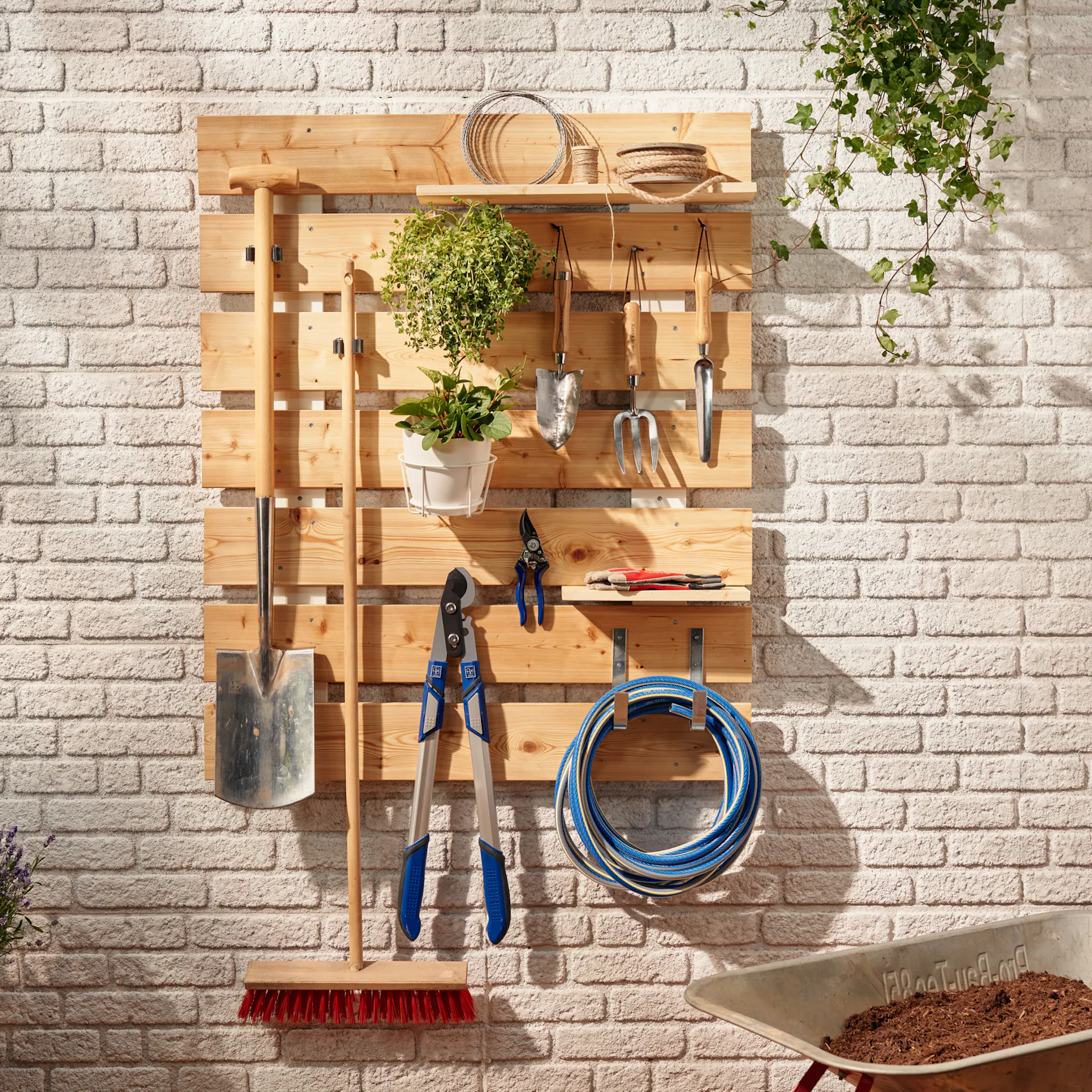 Wandorganizer mit verschiedenen Gartenutensilien und Werkzeugen.