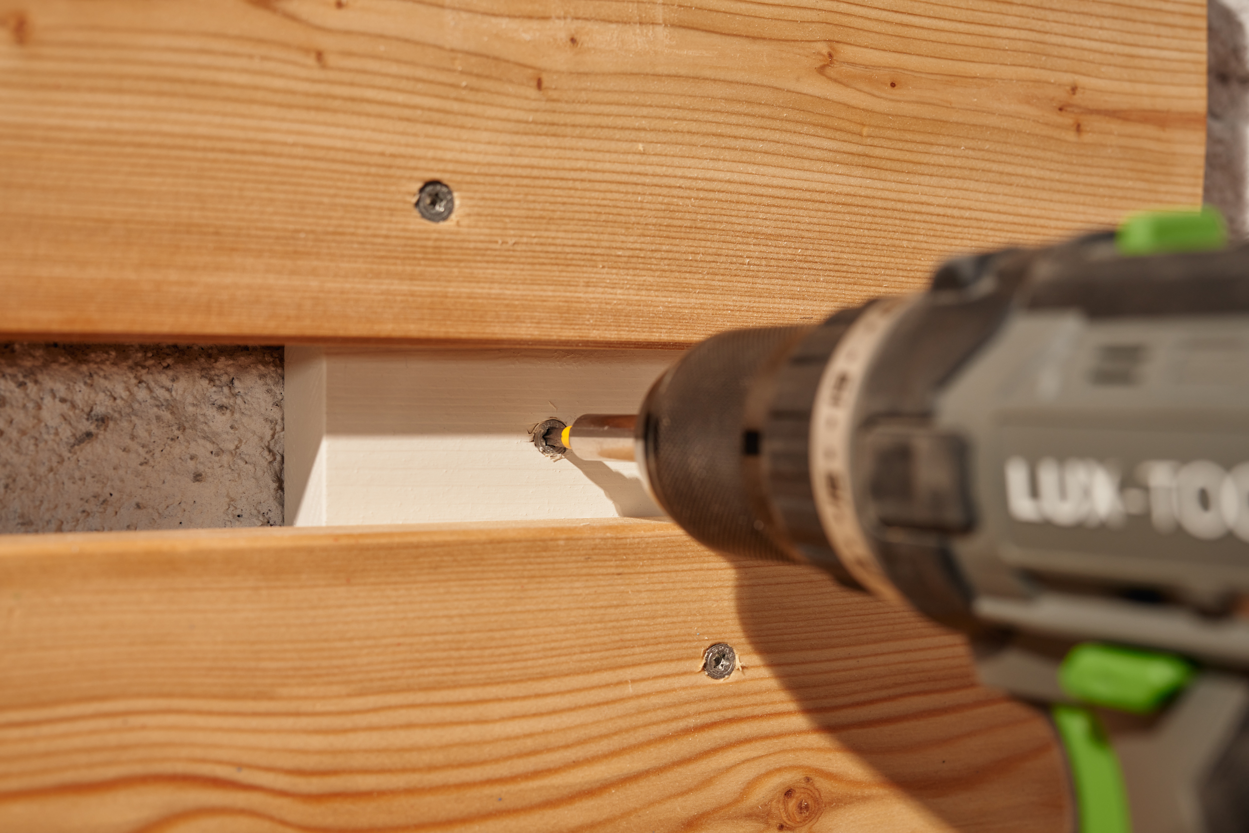 Organizer wird an eine Wand geschraubt