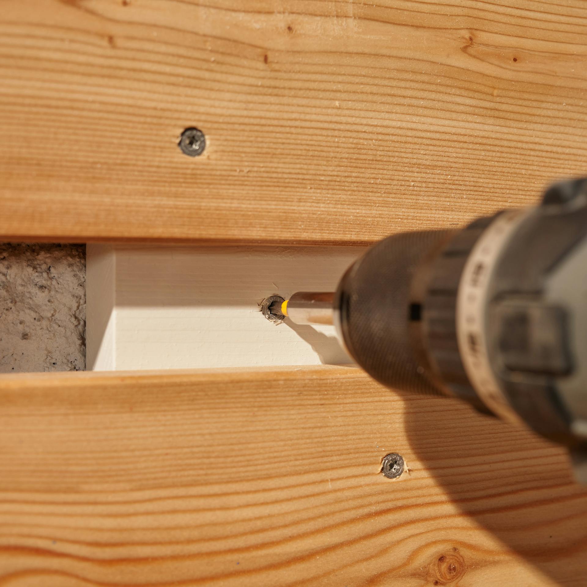 Organizer wird an eine Wand geschraubt