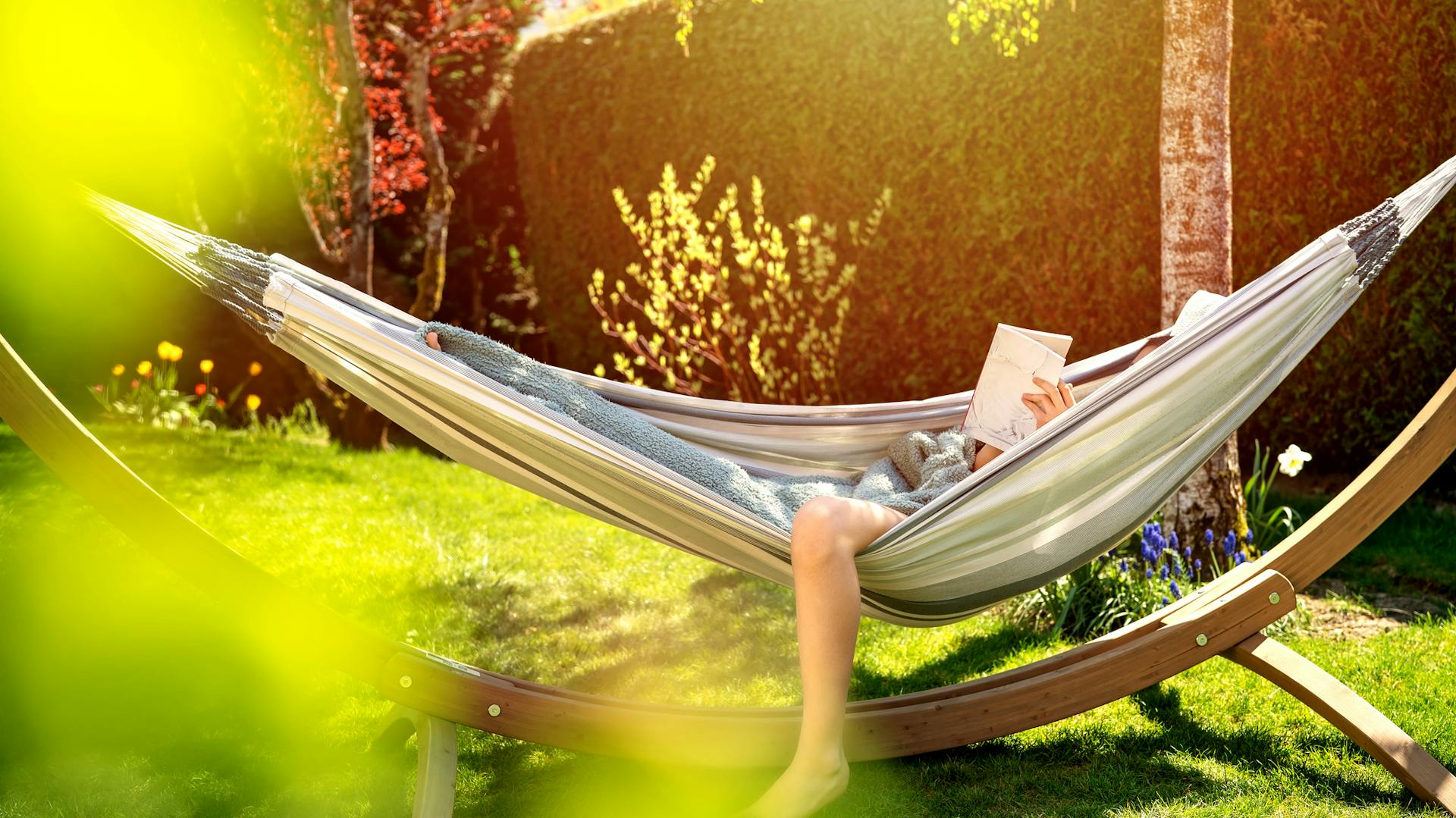 Jemand liegt in einer Hängematte im Garten