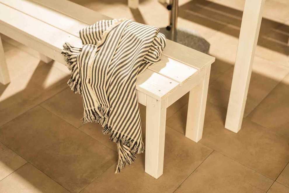 Gartenbank Sophie in Weiß, auf der eine Decke liegt