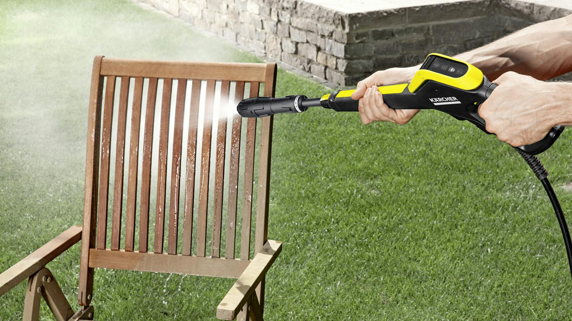 Reinigung von Gartenstuhl aus Holz mit Hochdruckreiniger auf Rasen