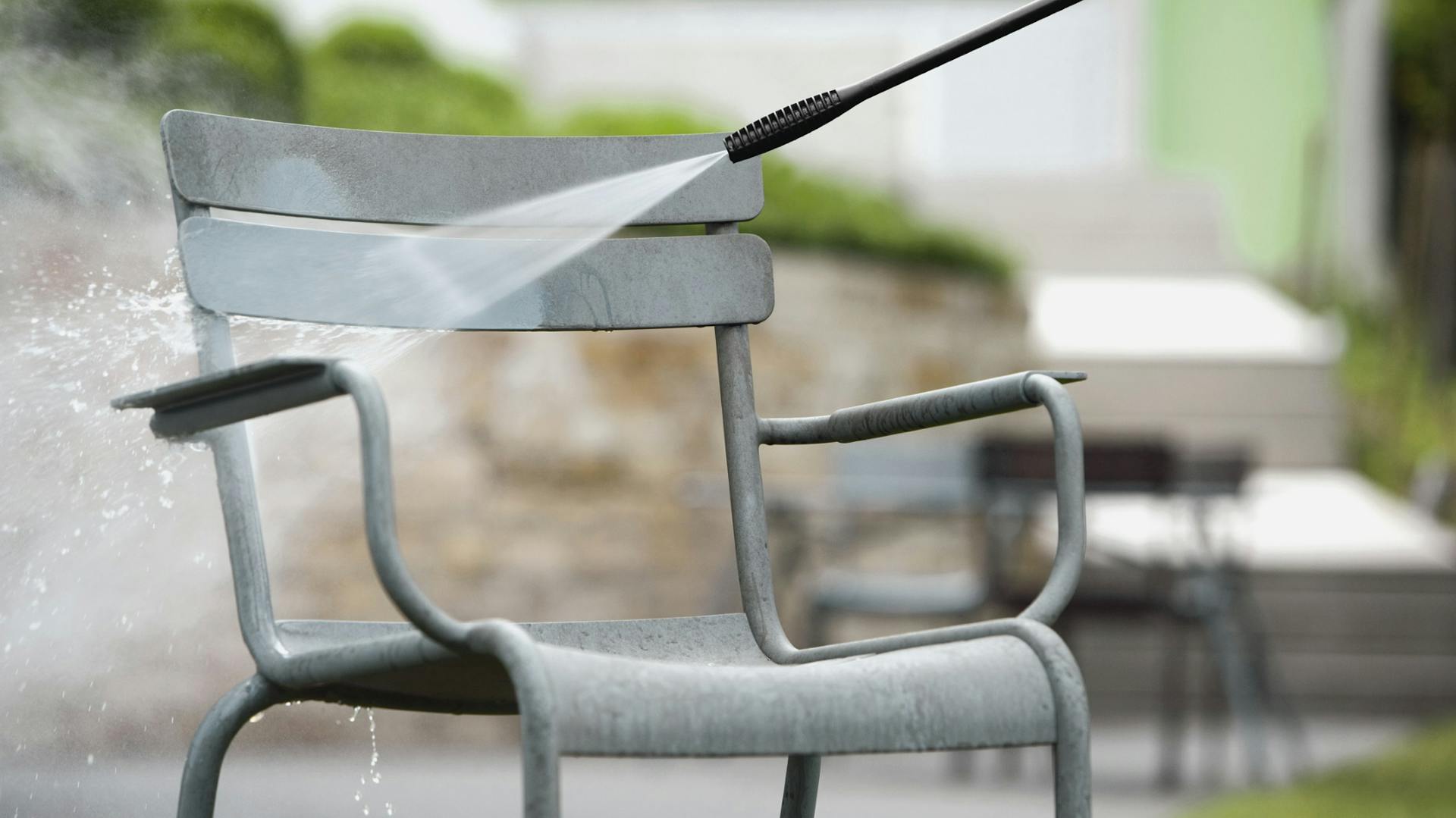Reinigung von blauem Gartenstuhl aus Aluminium Hochdruckreiniger vor Terrasse