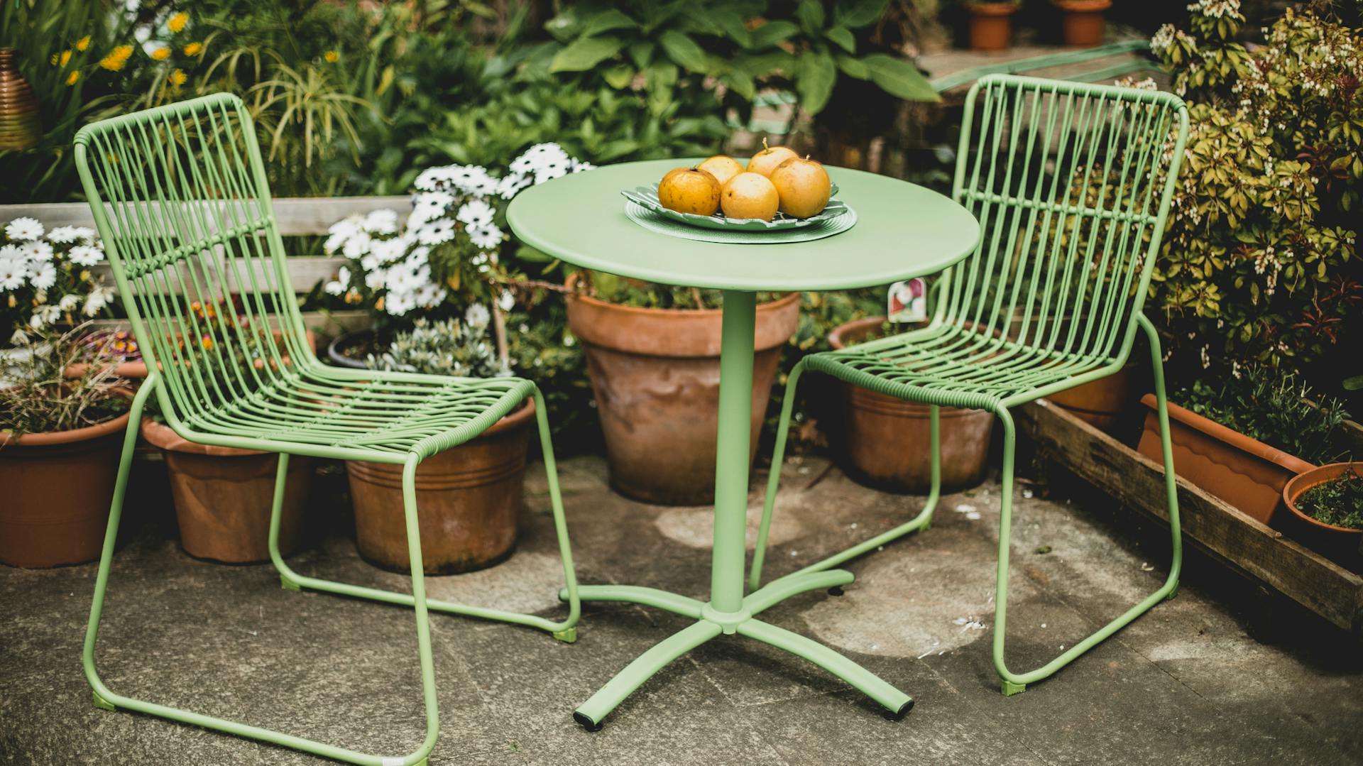 Grüne Gartenmöbel aus Kunststoff stehen im Garten.