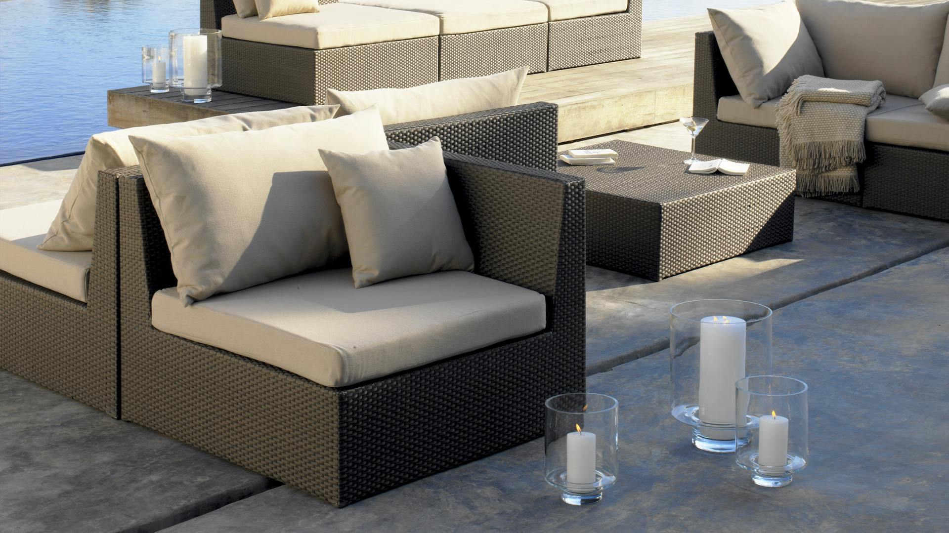 Moderne Gartenmöbel aus Polyrattan stehen am Pool.