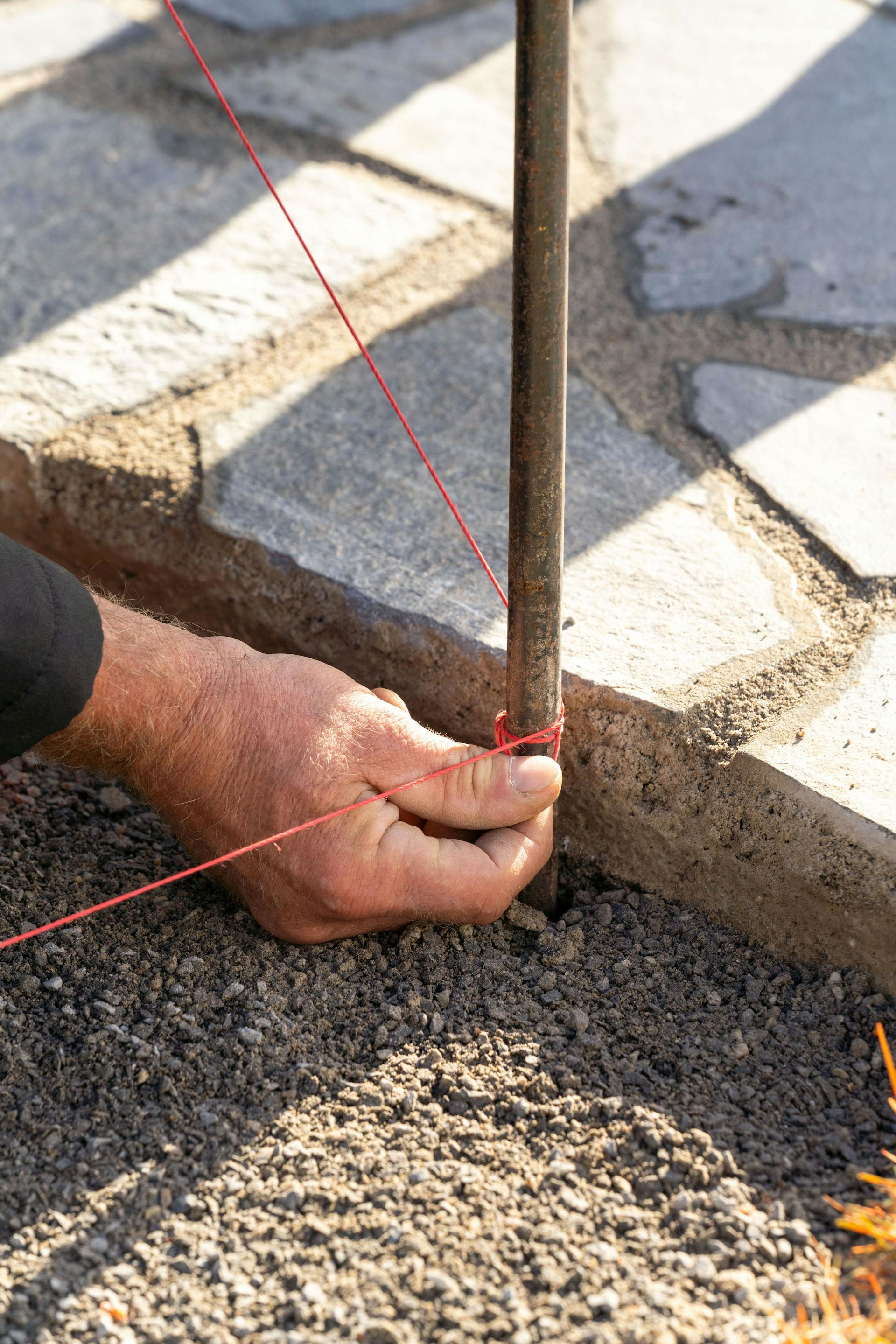 Una mano annoda una corda a un picchetto