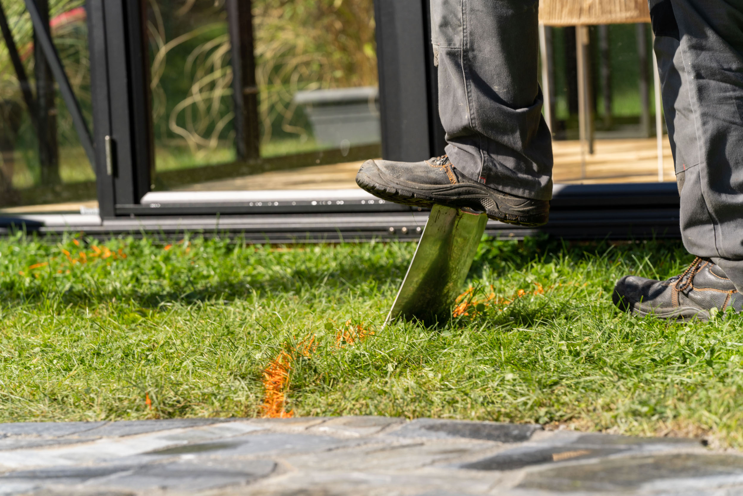 Una persona calpesta una vanga inserita nel terreno