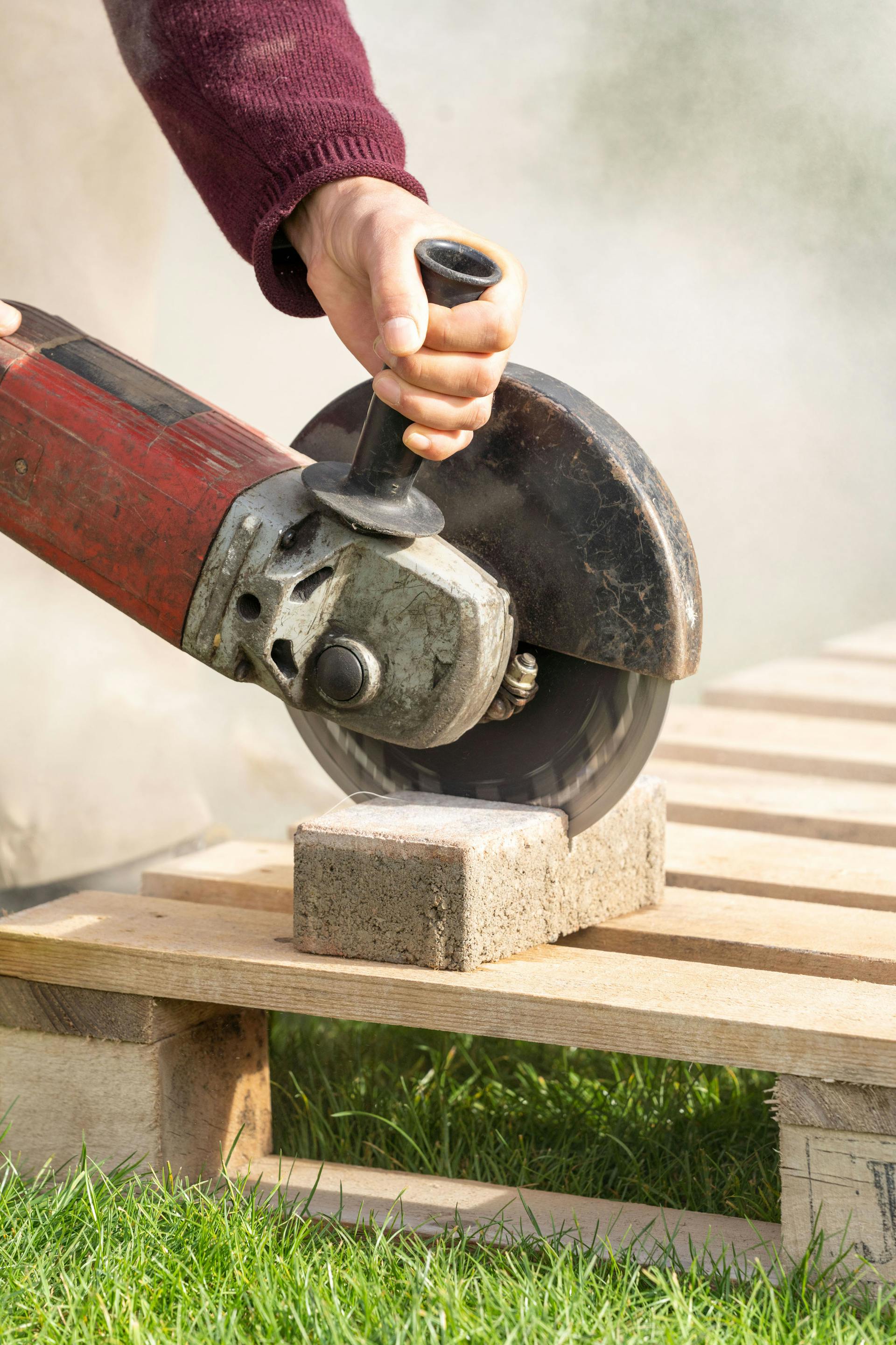Una pietra per selciati viene tagliata a misura con una smerigliatrice angolare