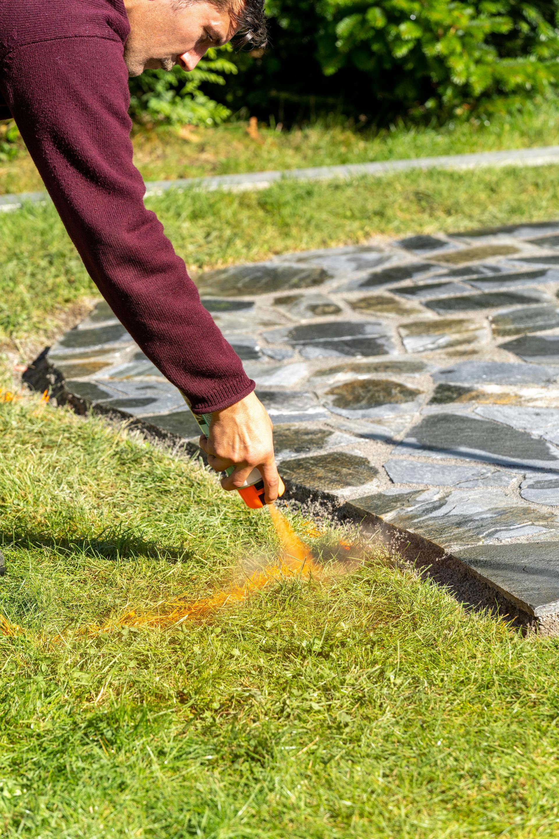 Spruzza un uomo sul prato con lo spray per marcatura