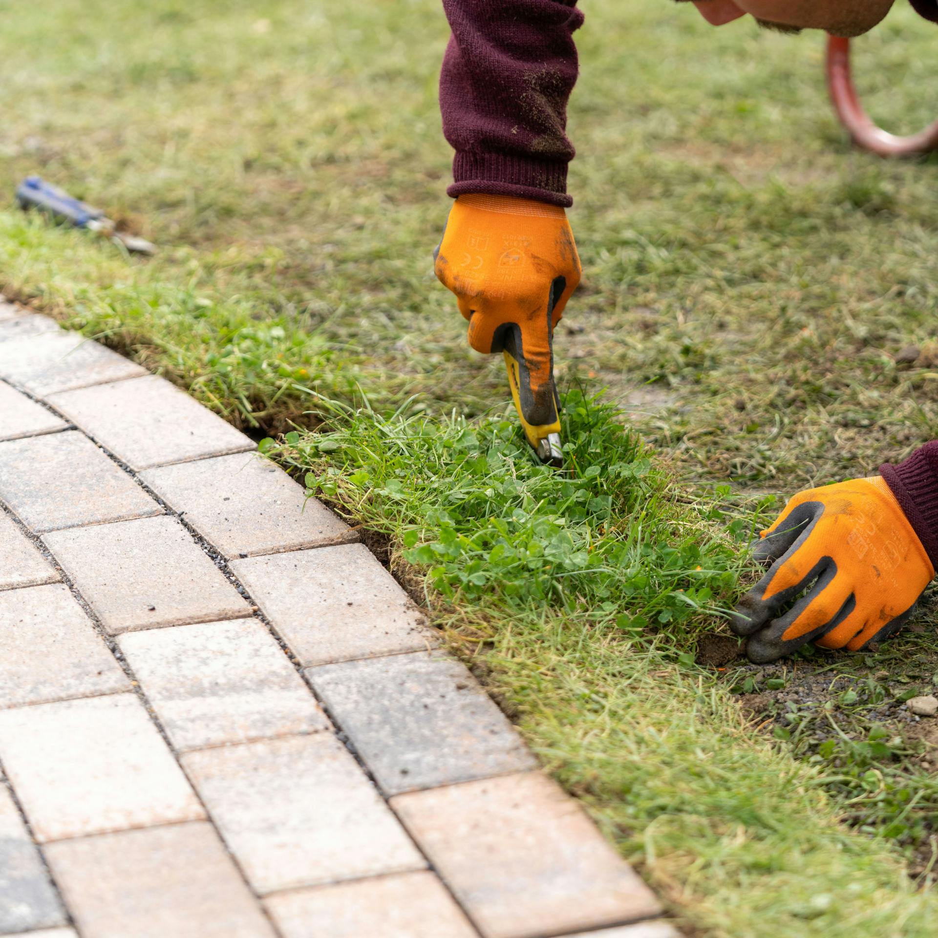 Ein Mann schneidet ein Stück Grasnarbe mit einem Cutter zu