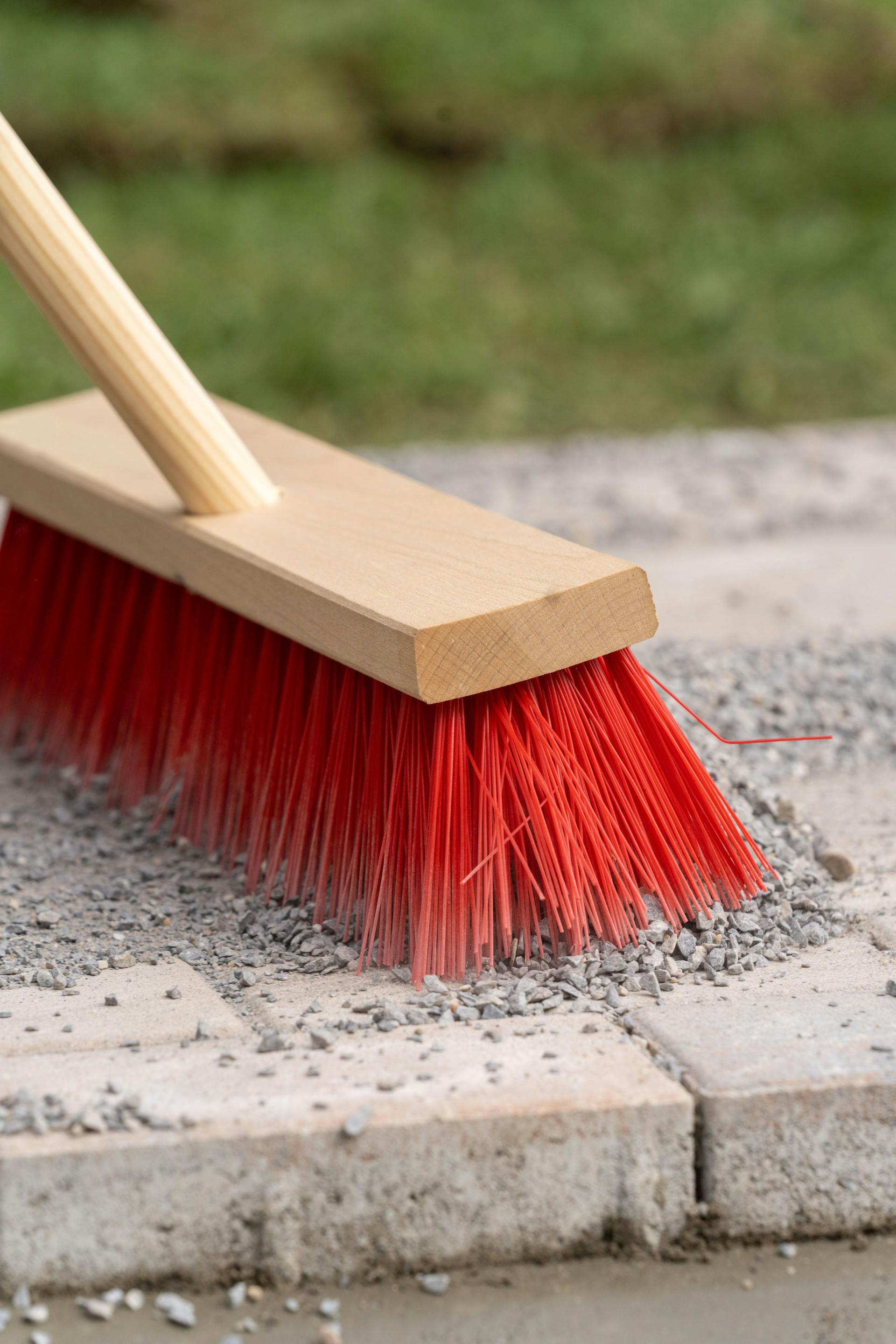 Una scopa con pietrisco su un sentiero pavimentato