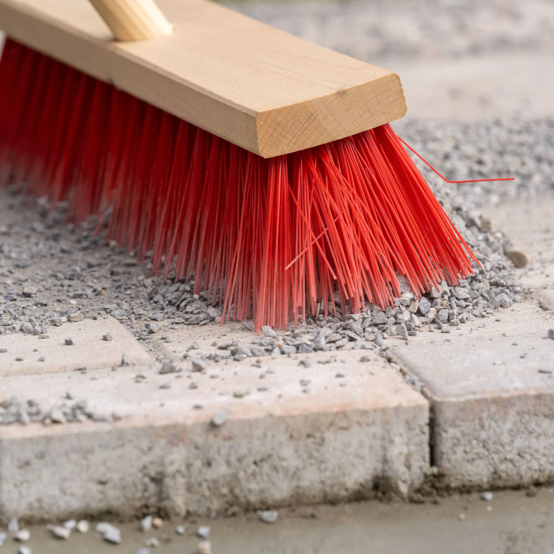 Koště se štěrkem na dlážděné cestě