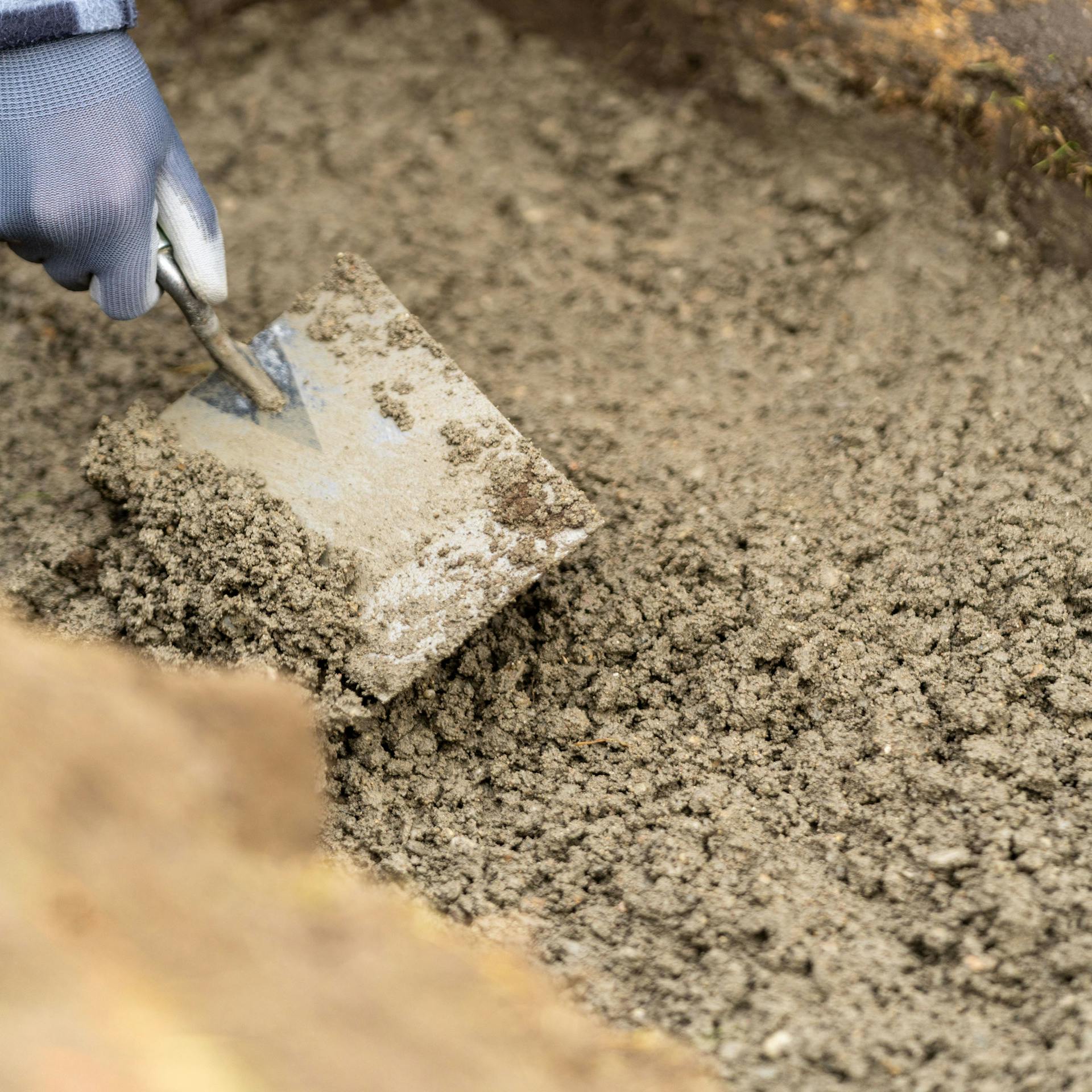 Beton wird mit Maurerkelle verteilt.