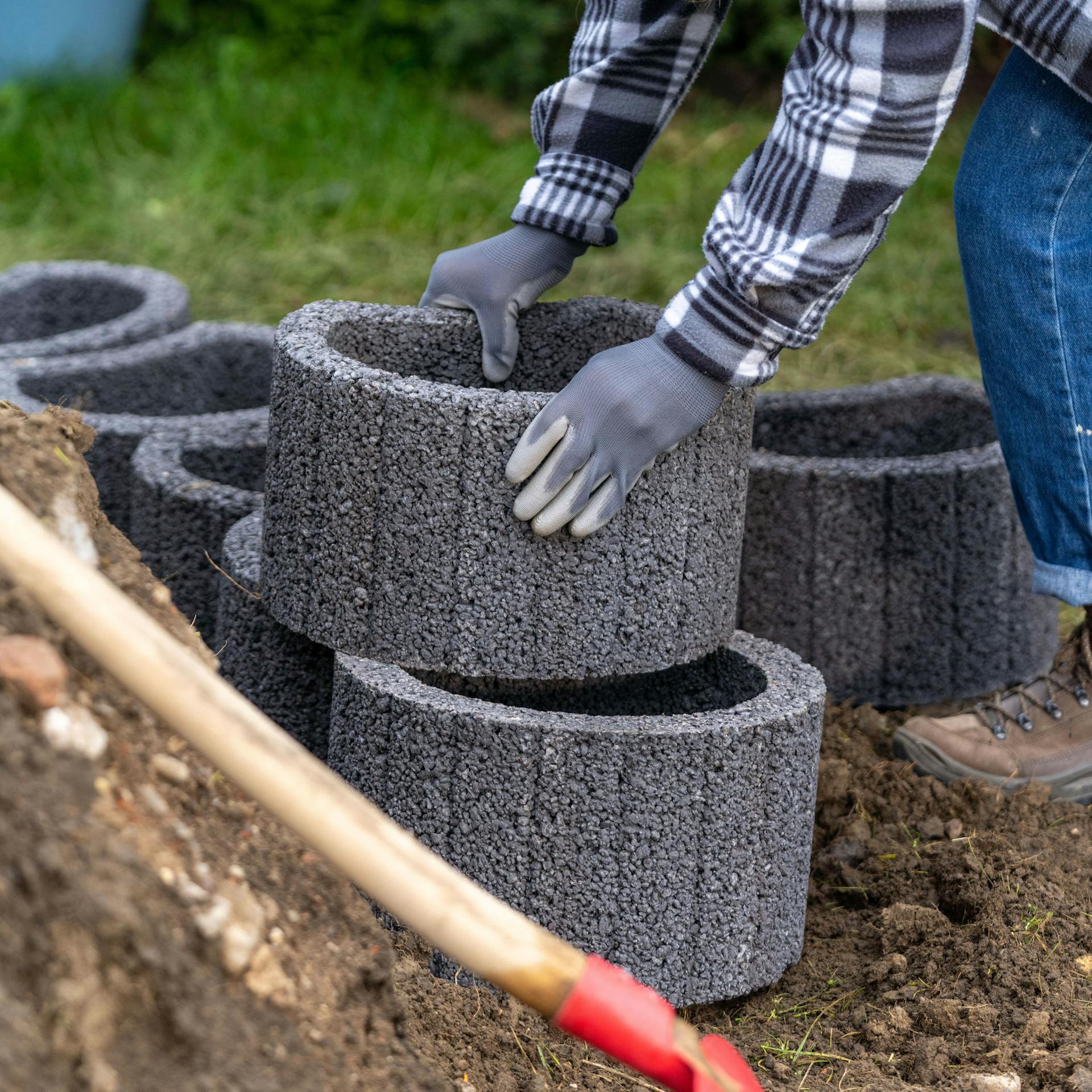 Frau platziert Pflanzsteine nebeneinander und aufeinander.