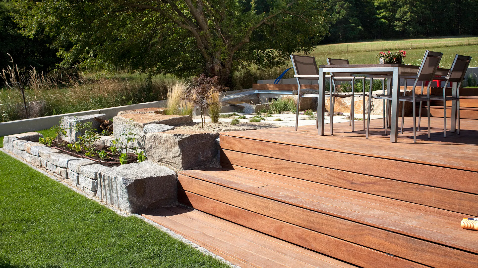 Svažitá zahrada s terasou.