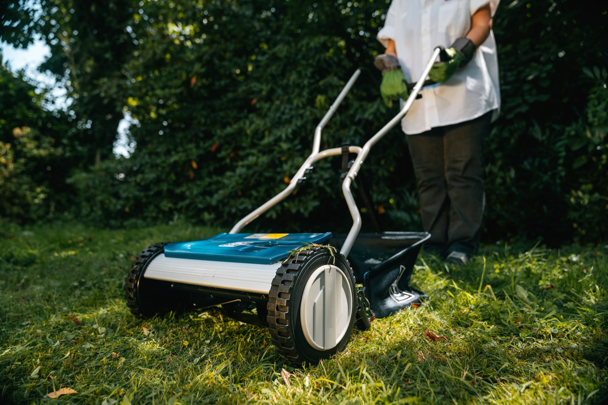 Egy nő füvet nyír az őszi kertben