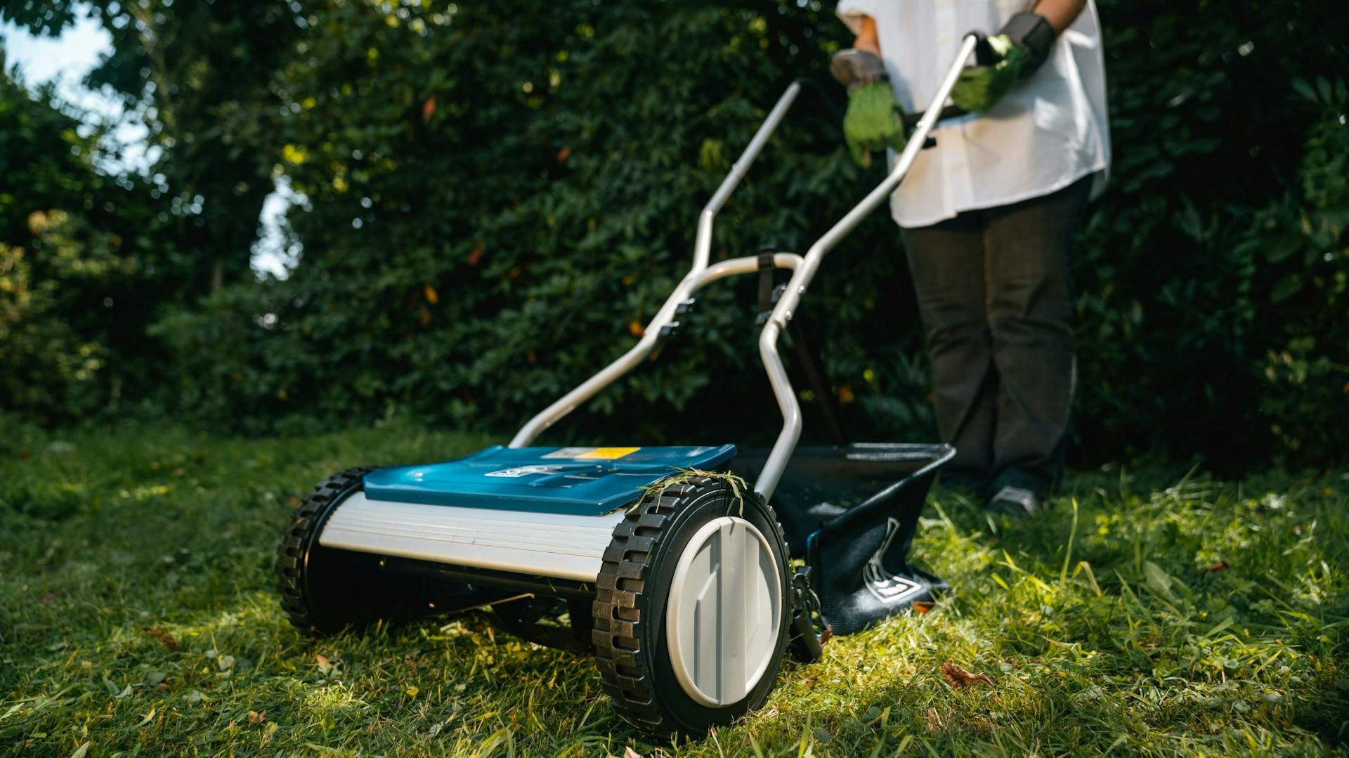 Egy nő füvet nyír az őszi kertben