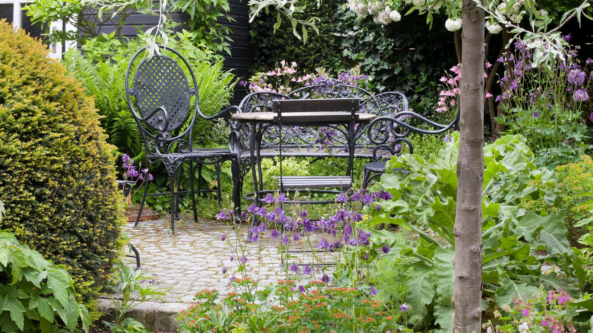 Tavolo e sedia sono allestite in un giardino adatto agli insetti.