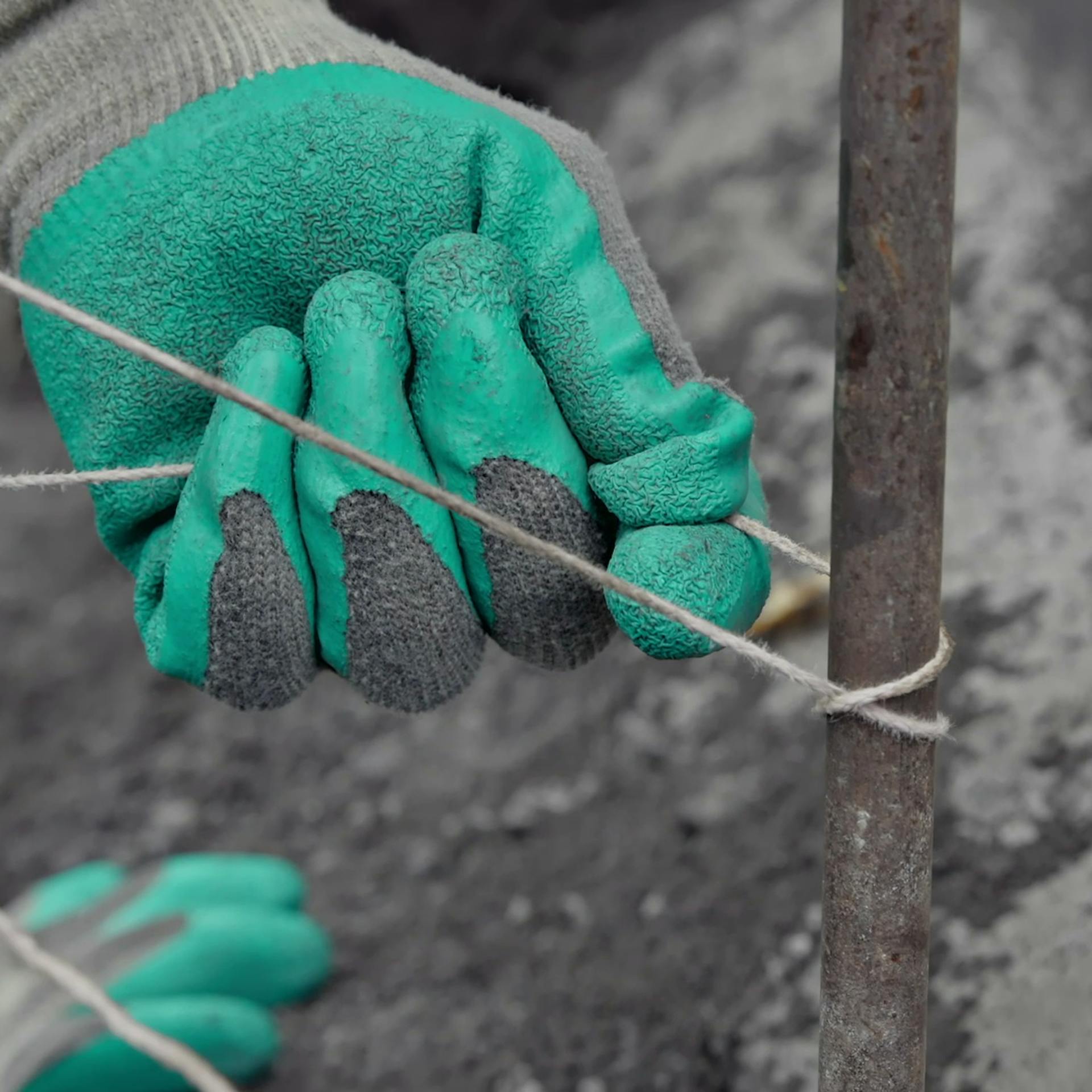 Heimwerker befestigt Schnur an Schnurnagel mit Mastwurfknoten.