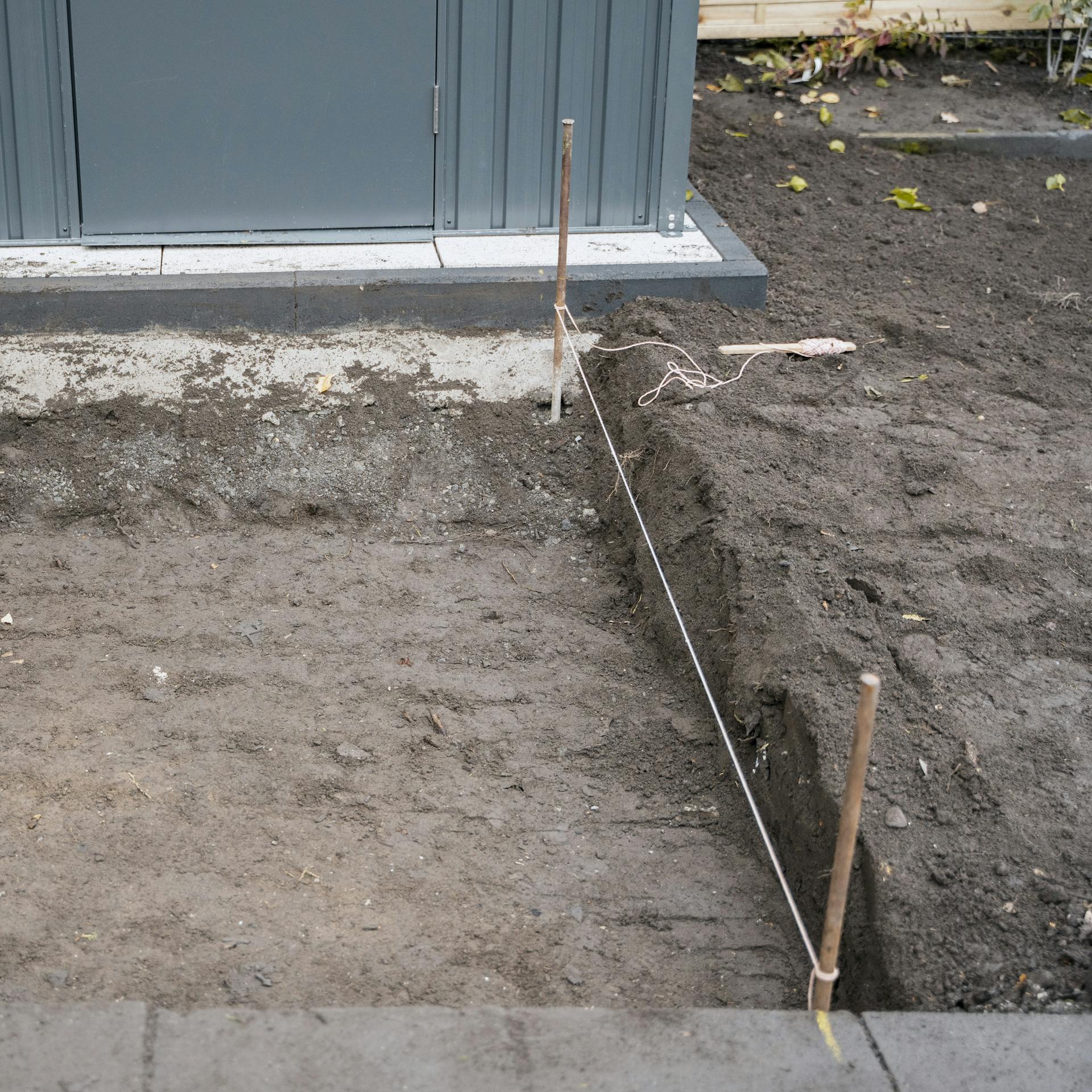 Ein Schnurgerüst an den Außenseiten eines ausgeschachteten Bodens