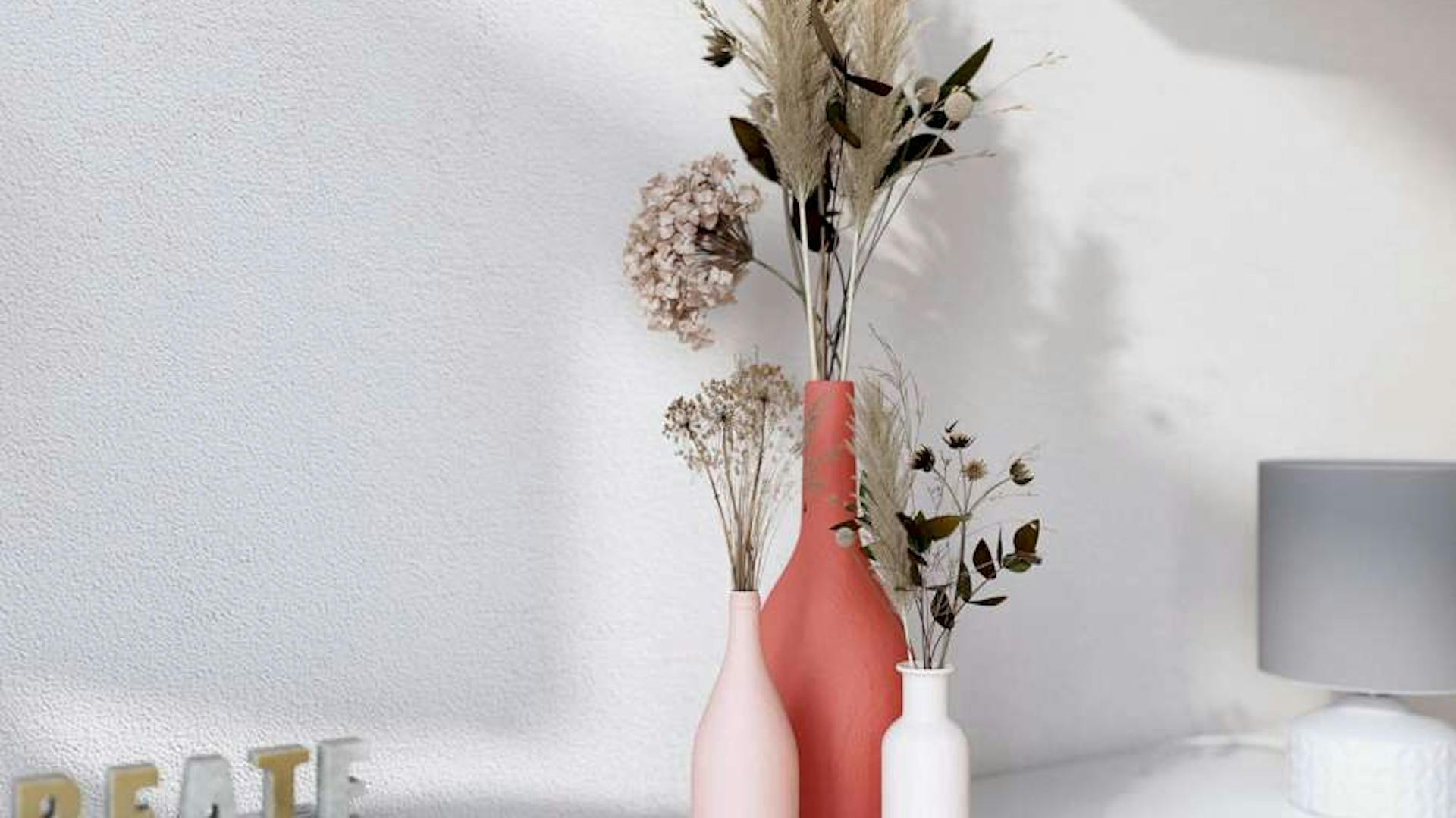 Bunte Vasen mit Trockenblumen.