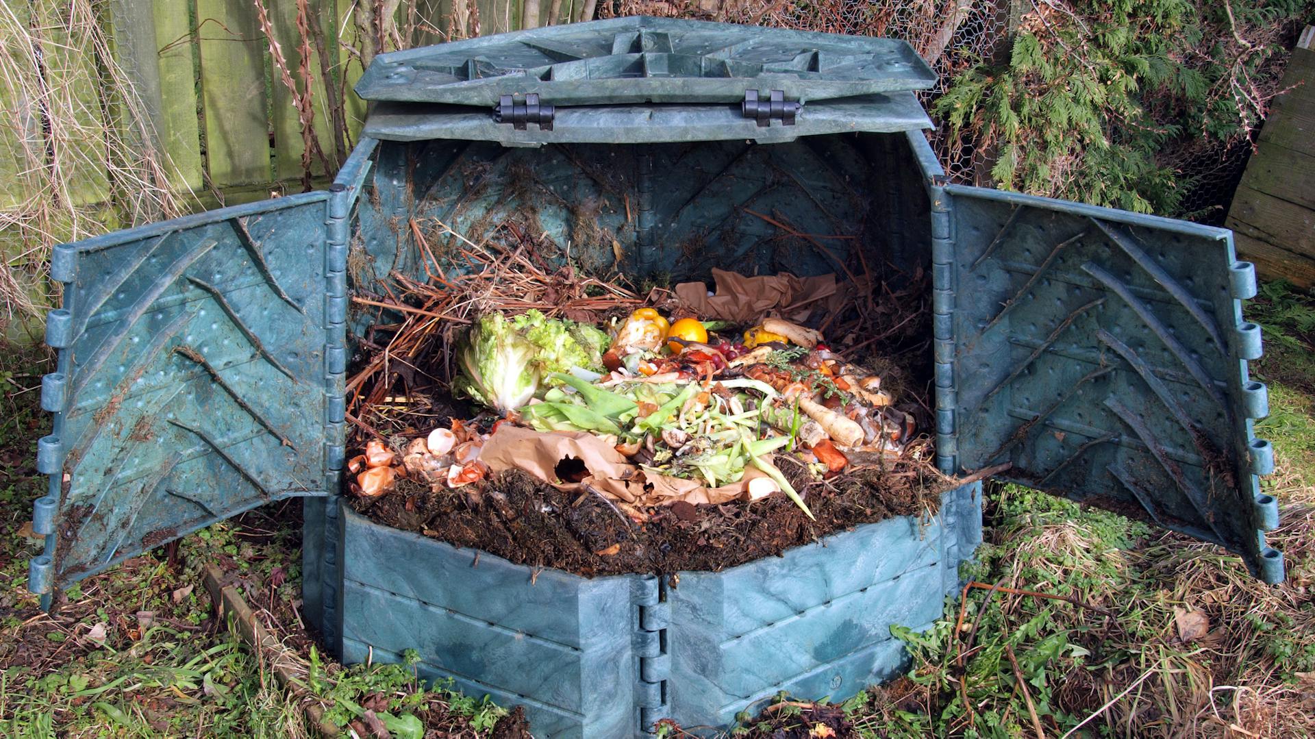 Ein geöffneter Komposter mit Gartenabfällen.