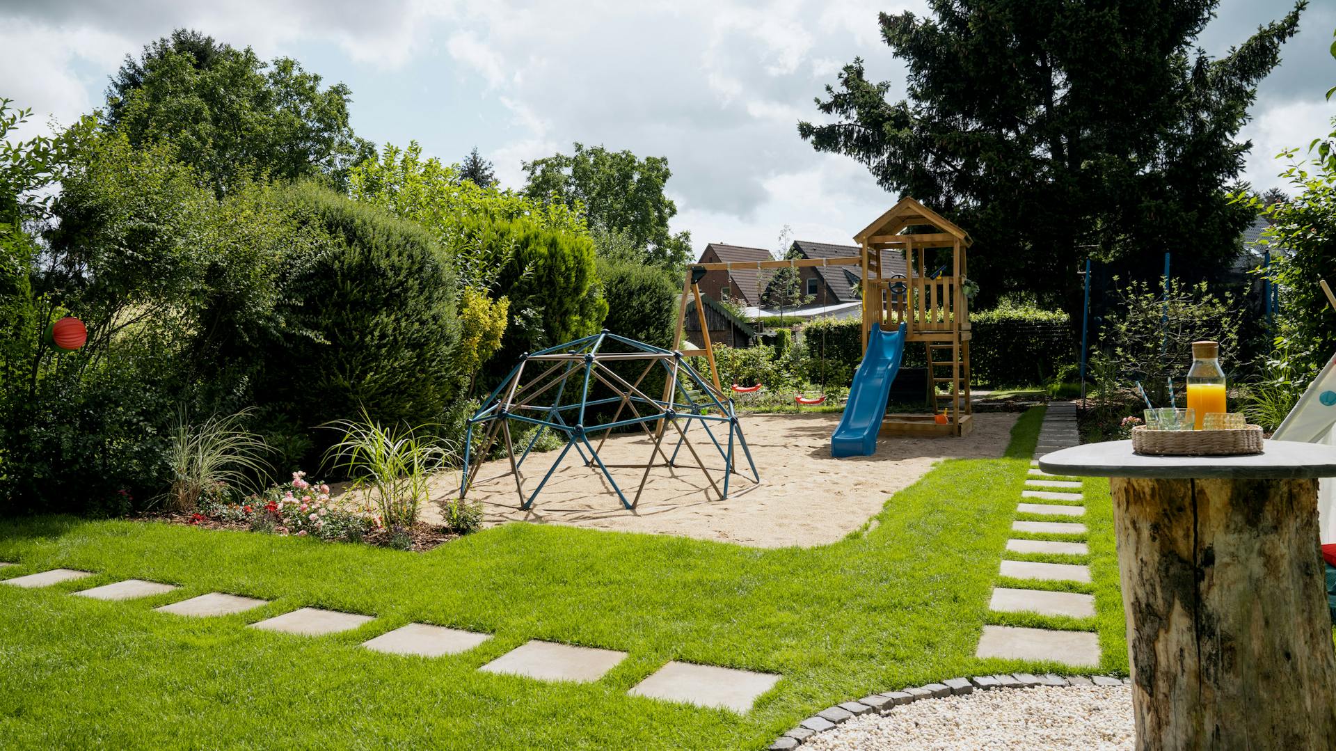 Spielgeräte im Garten mit Pflastersteinen und Terrasse