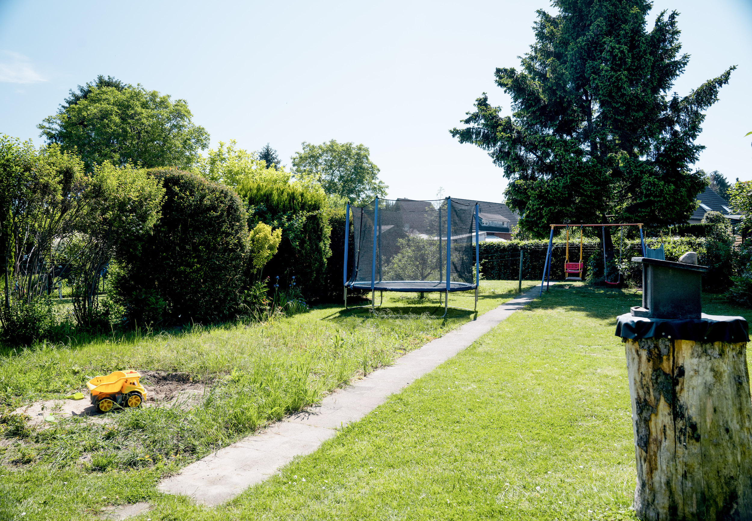 Garten mit Trampolin und Schaukel im Hintergrund