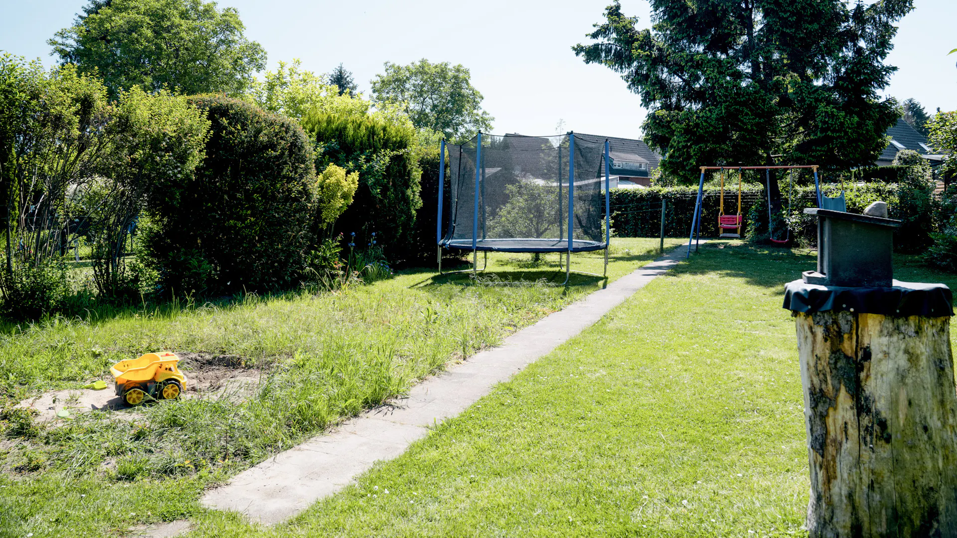 Garten mit Trampolin und Schaukel im Hintergrund