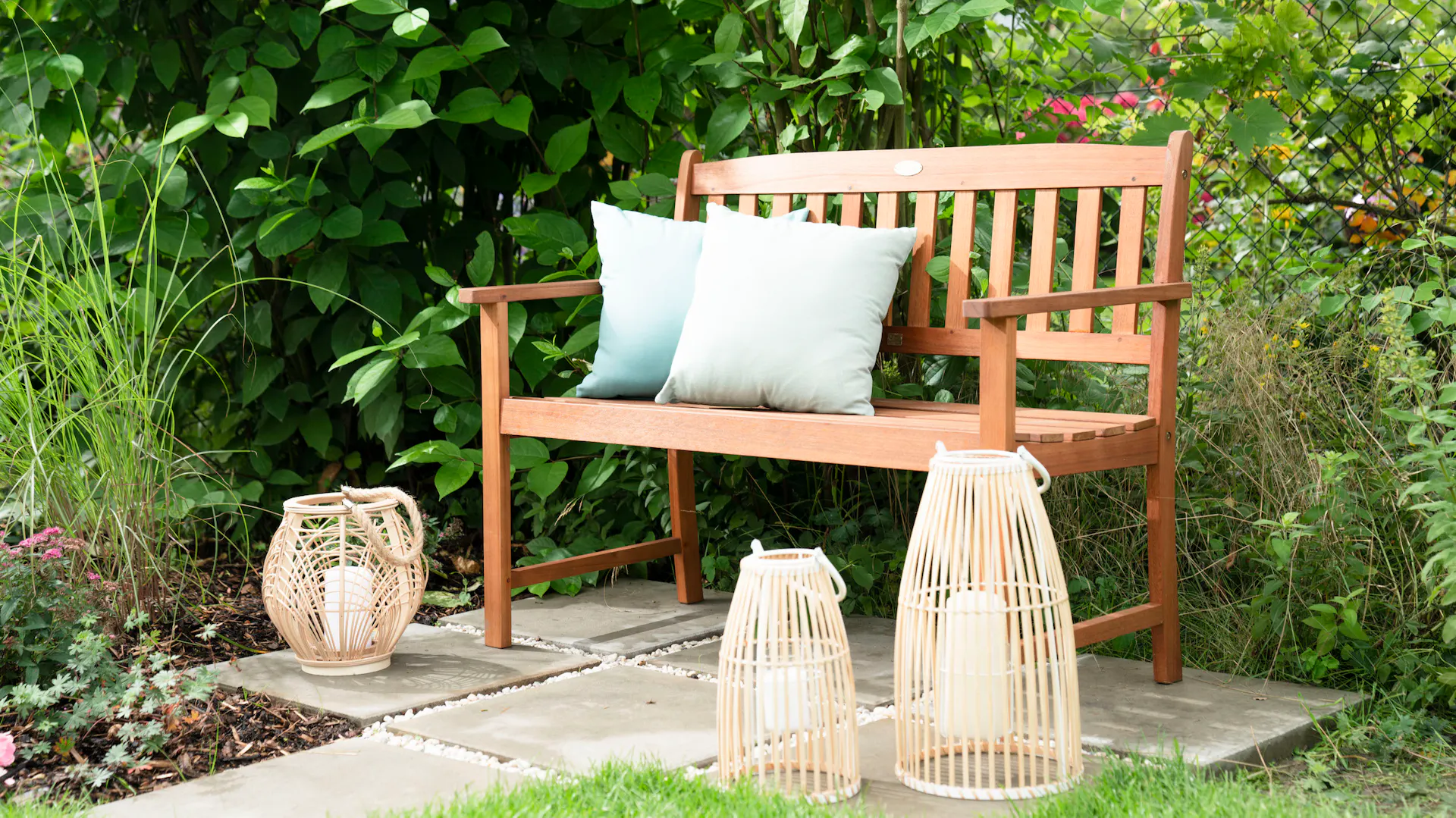Gartenbank mit Laternen und Kissen