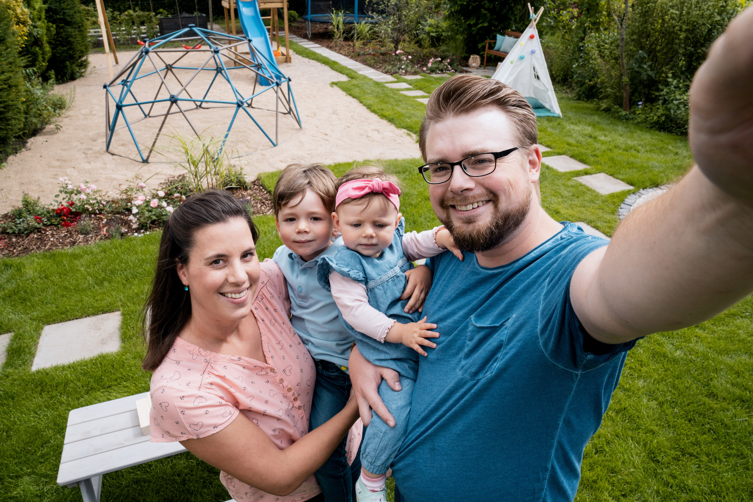Zwei Personen mit Kindern vor einer Spielfläche