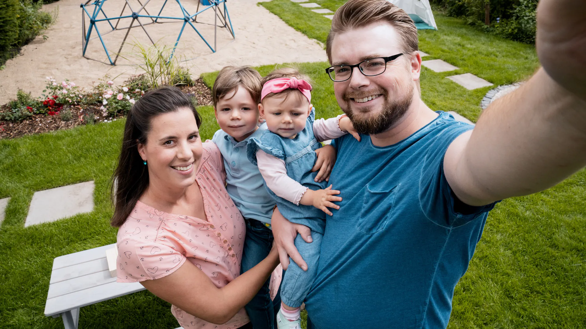 Zwei Personen mit Kindern vor einer Spielfläche