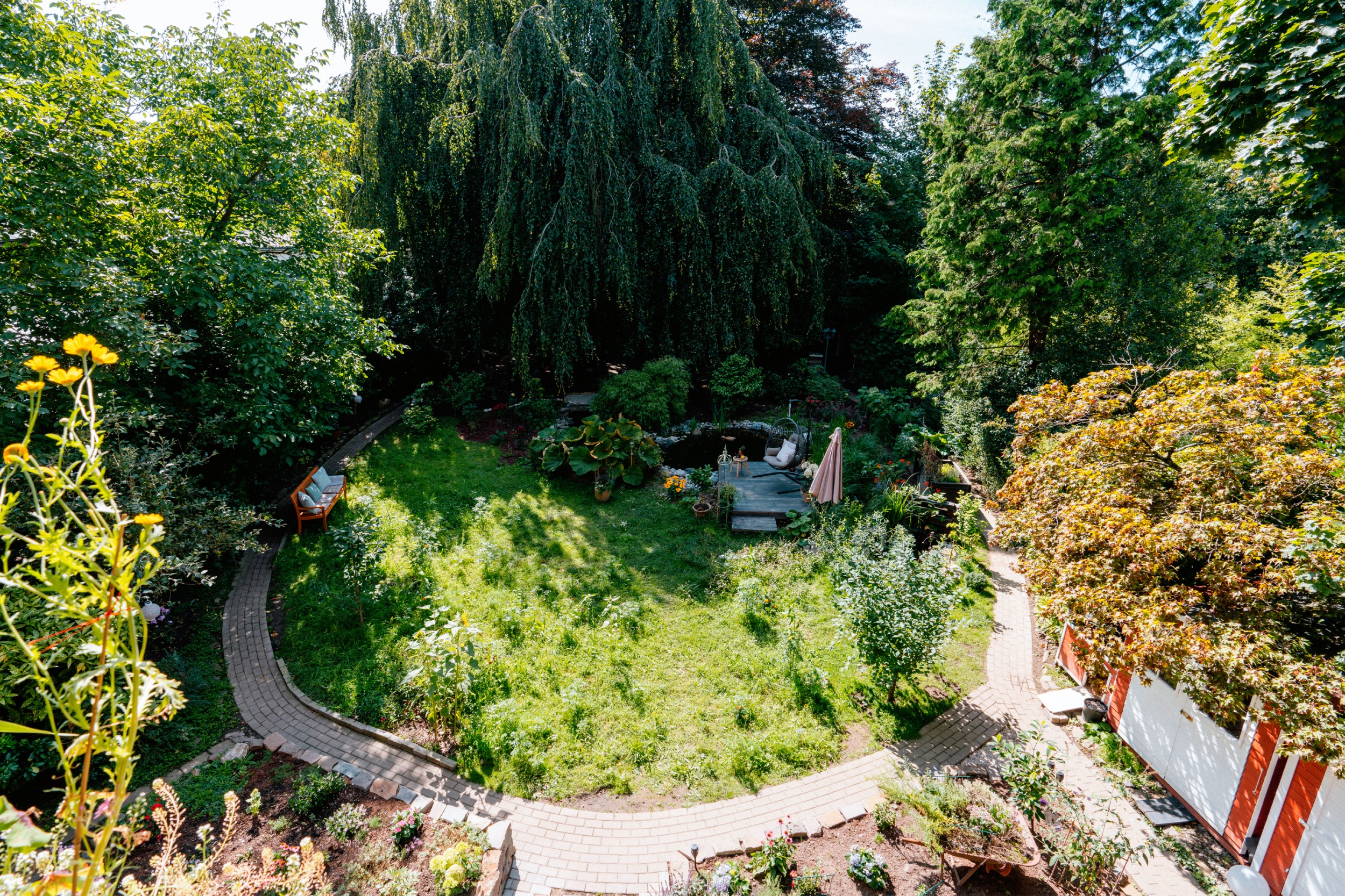 Garten mit Wildwiese und Teich von oben
