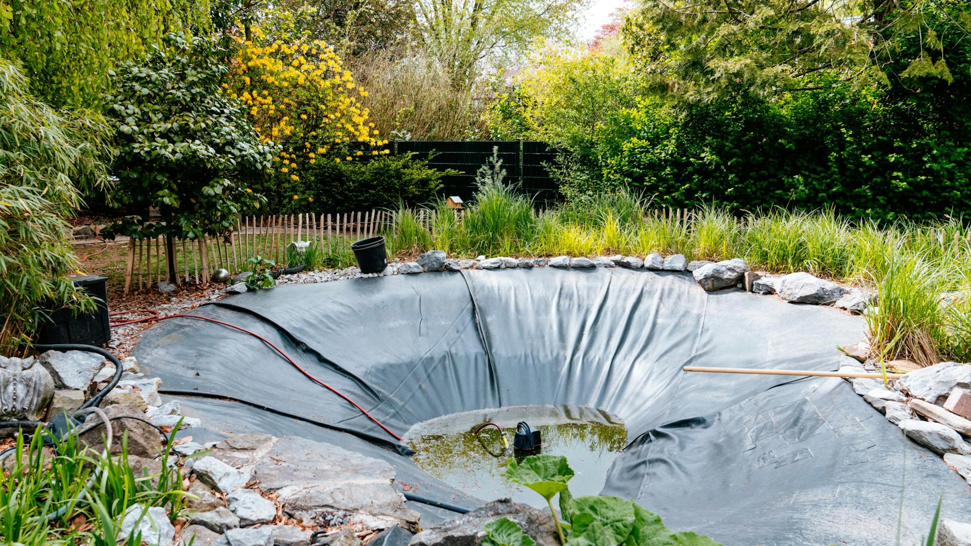 Leerer Teich, der mit Teichfolie verkleidet ist