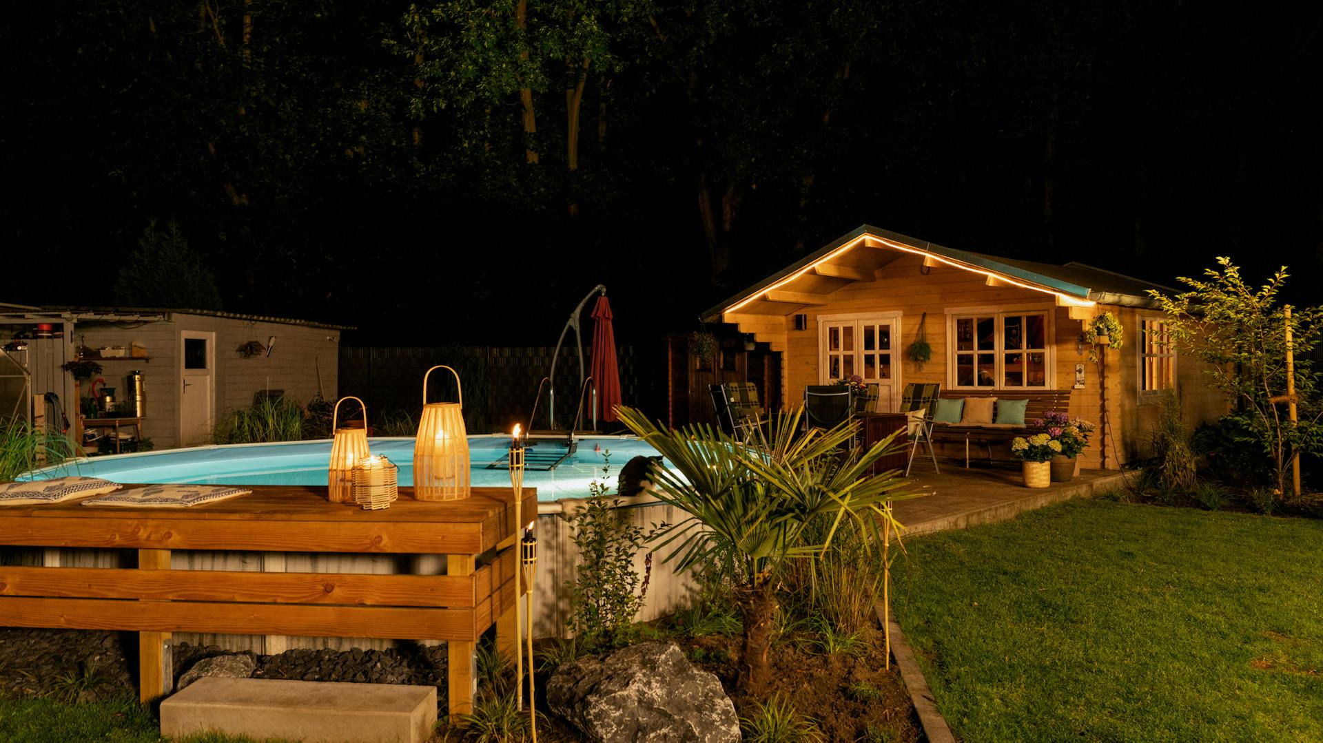 Beleuchteter Pool vor einem Gartenhaus