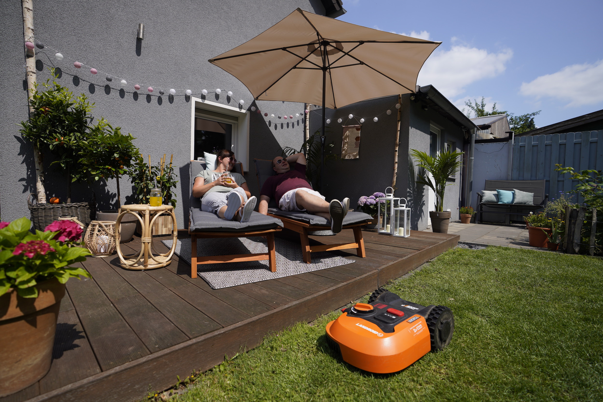 Zwei Personen auf Sonnenliegen auf Terrasse