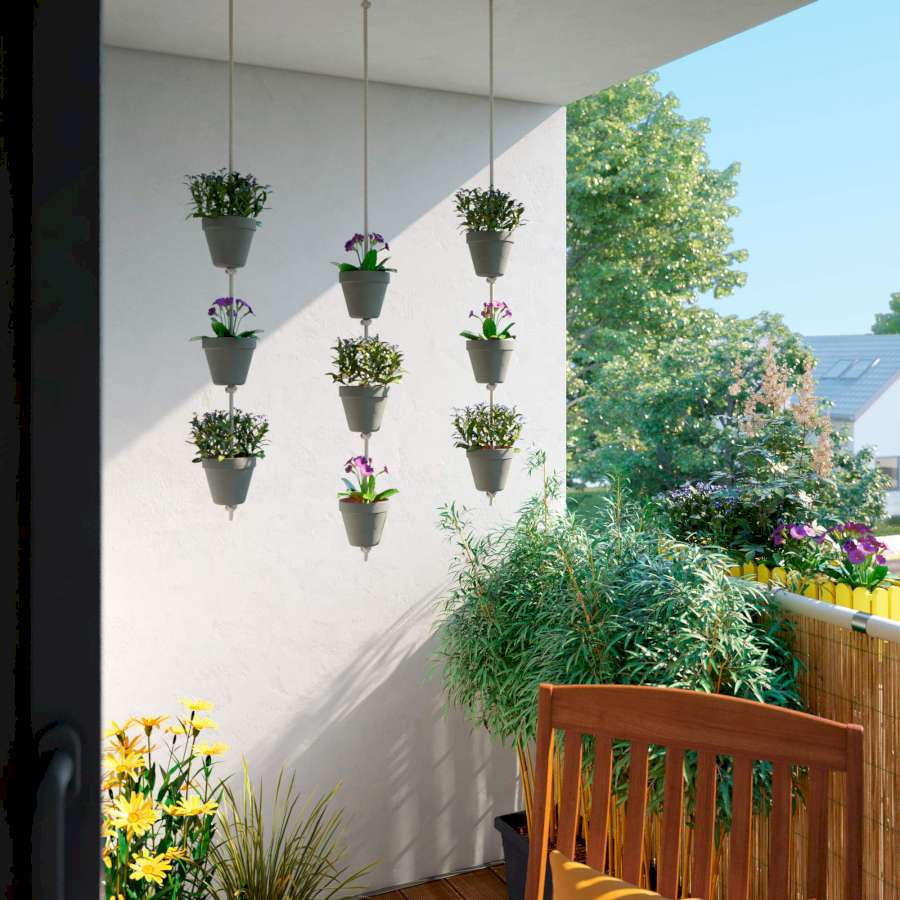 Auf einem Balkon sind Hängetöpfe an der Überdachung angebracht