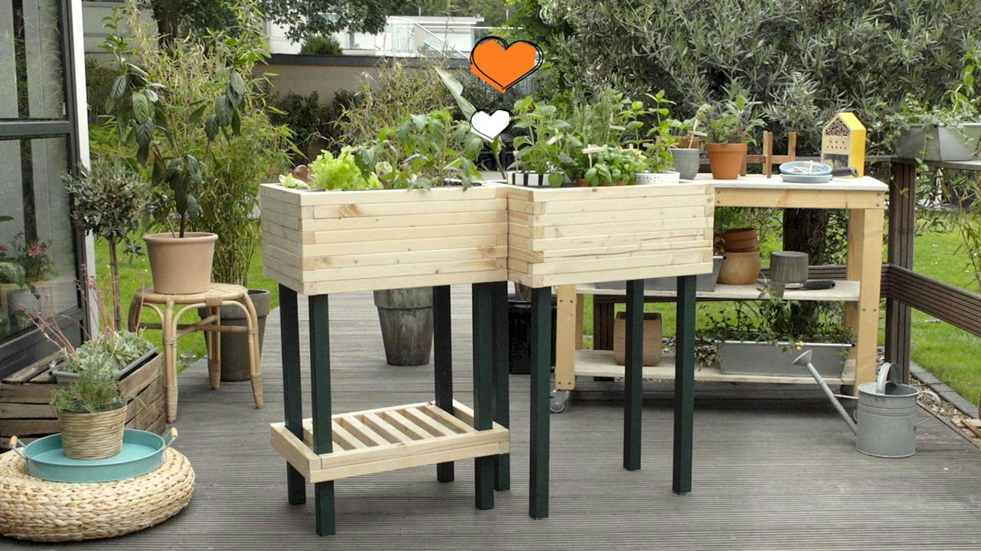 Ein modulares Hochbeet steht auf einer Terrasse vor weiteren Pflanzen und einem Regal mit Blumentöpfen.