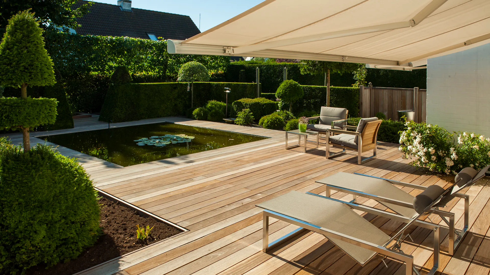 Una tenda da sole su una casa con laghetto