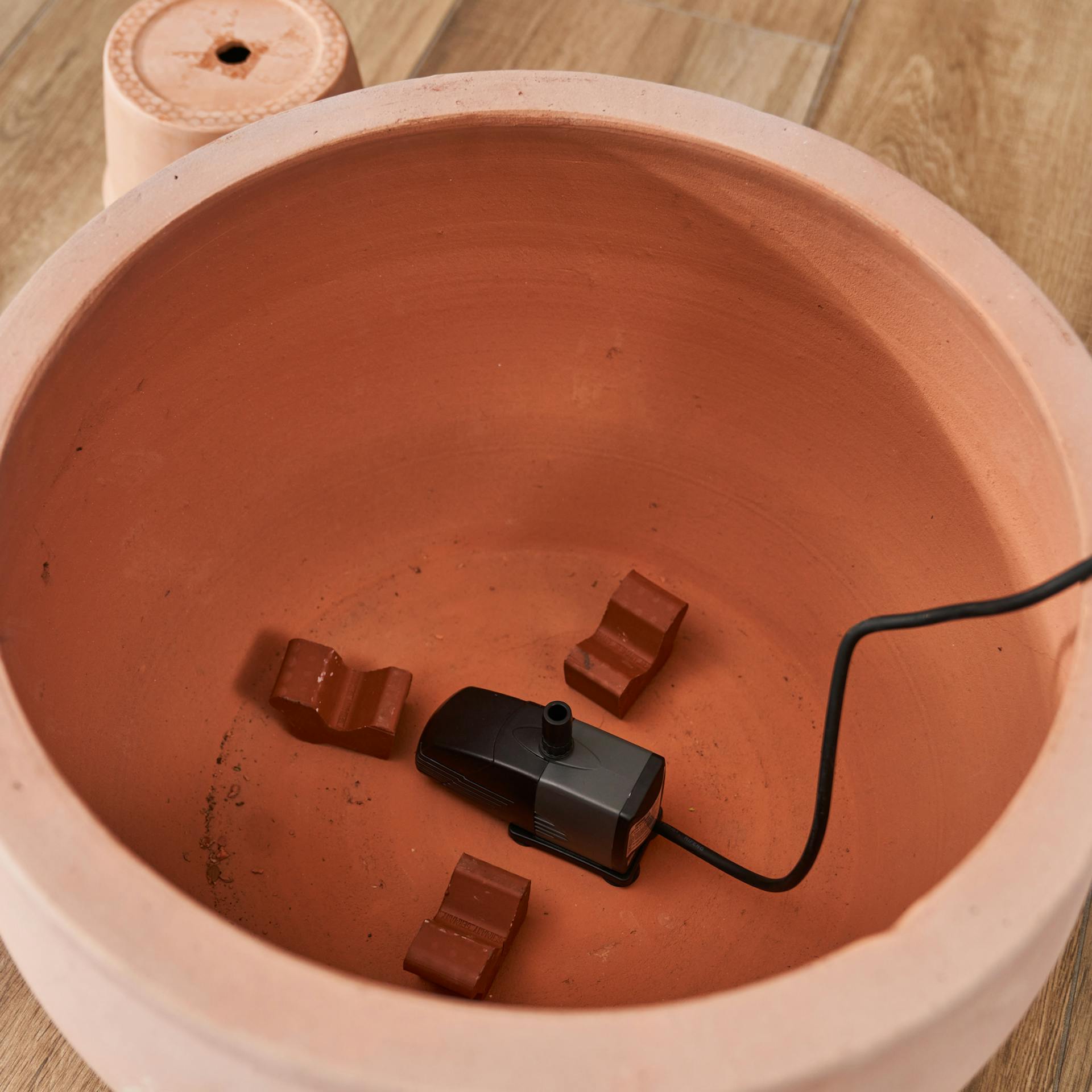 Die Pumpe im untersten Pflanztopf mit Blumetopffüßen.