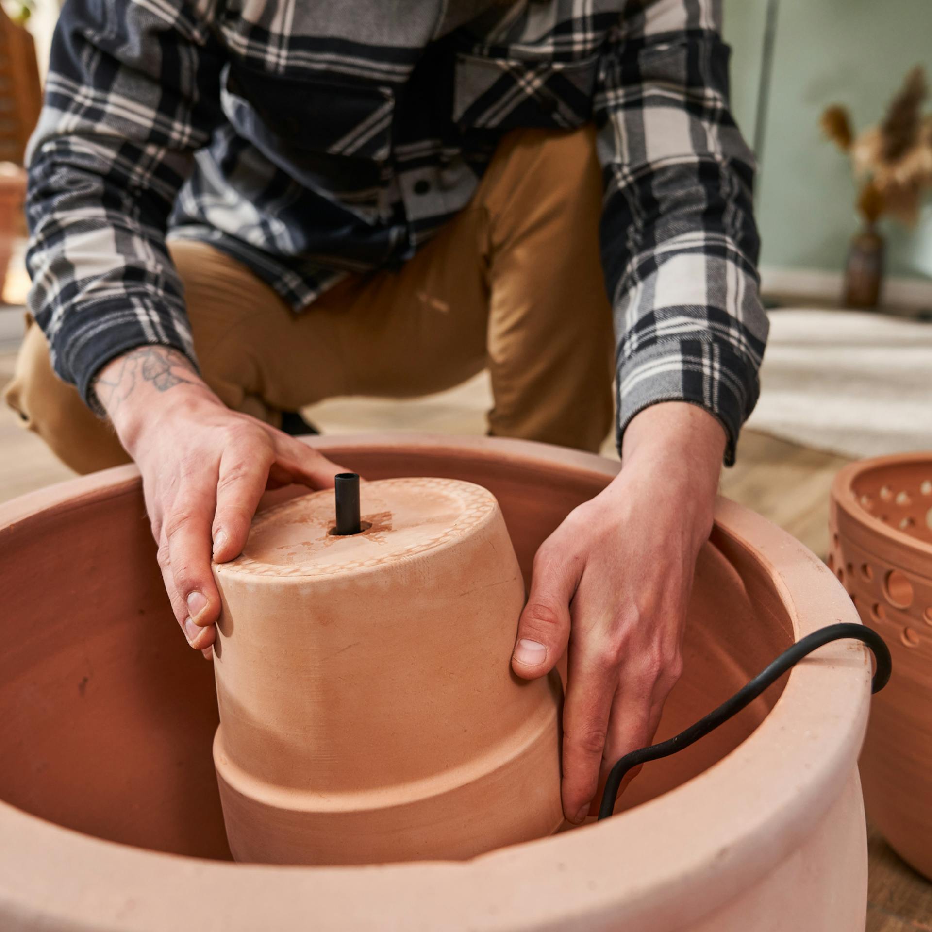 Pflanztopf wird über die Pumpe und das Pumprohr gestülpt.