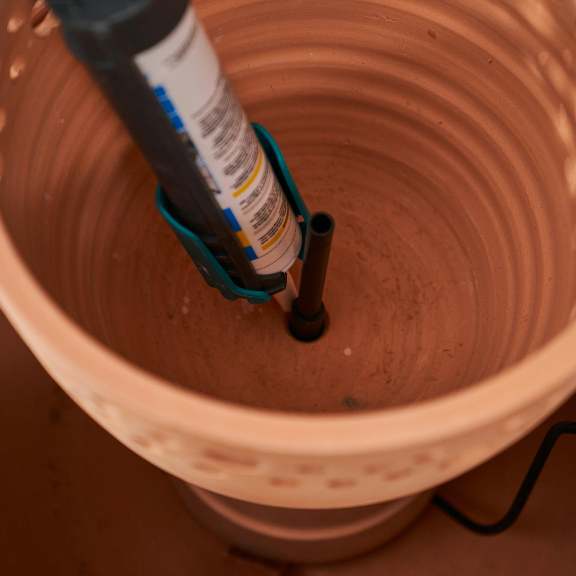 Mittlerer Pflanztopf wird mit Montagekleber abgedichtet.