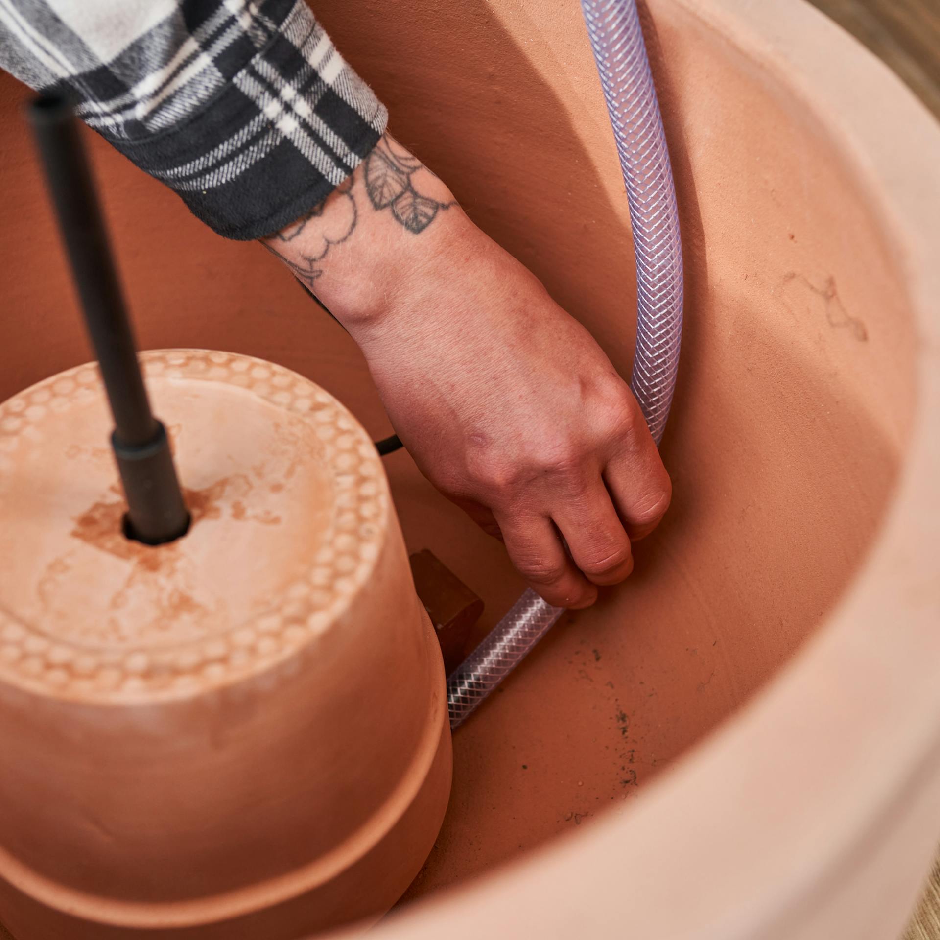 Ein Schlauch wird zur Entlüftung unter den ersten Pflanztopf gelegt.